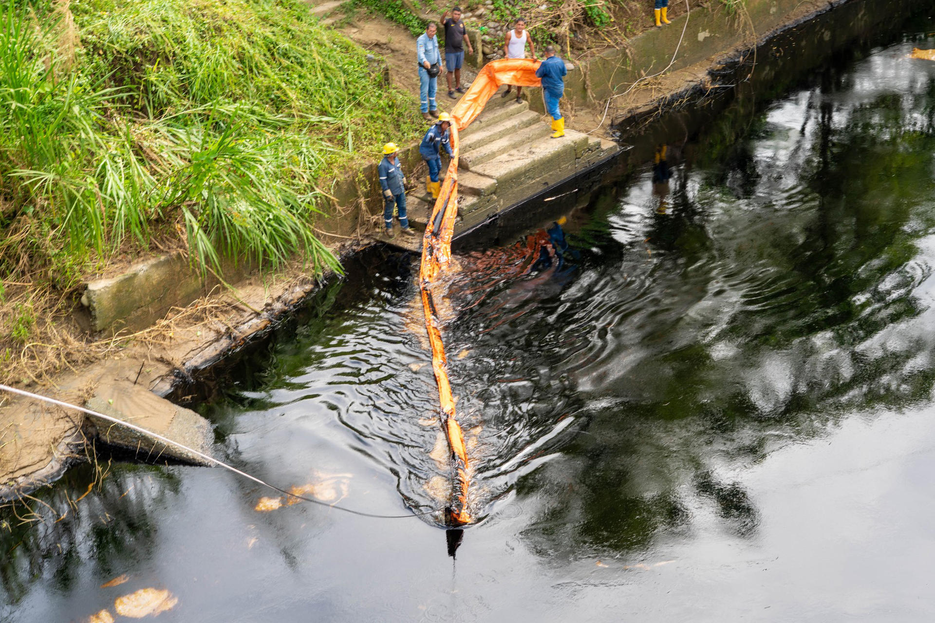 Fotografía cedida este viernes por el Cuerpo de Bomberos de Esmeraldas de personas trabajando en el rio Viche, afectado por el derrame de petroleo en la tubería principal del Sistema de Oleoductos Transecuatoriano (Sote), en el municipio de Quinindé (Ecuador). EFE/ Bomberos De Esmeraldas