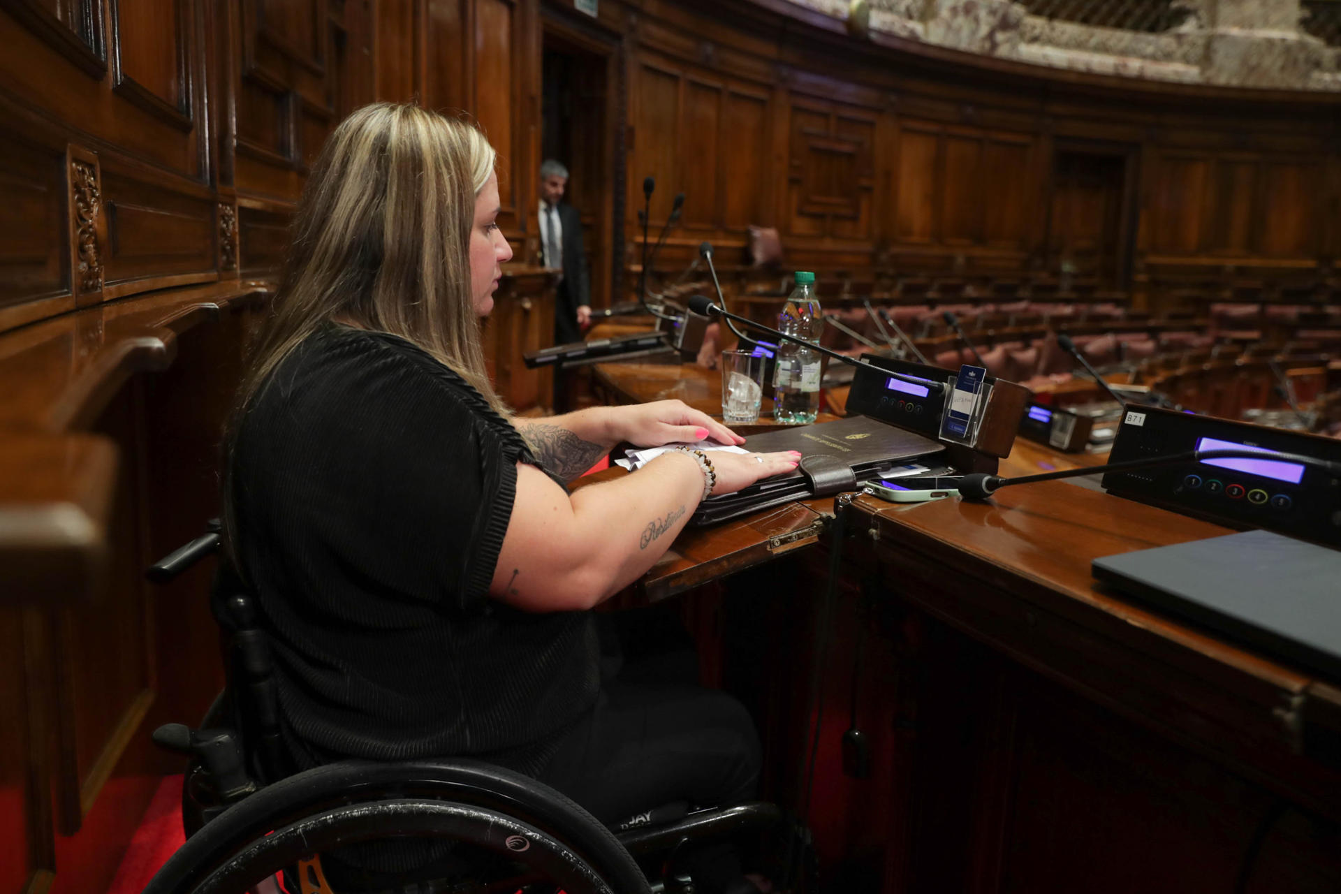 La diputada suplente por el oficialista Frente Amplio, Fiorella Buzeta, asiste a una sesión tras convertirse en la primera legisladora con una discapacidad motriz en asumir una banca este martes, en el Palacio Legislativo en Montevideo (Uruguay). EFE/ Alejandro Prieto