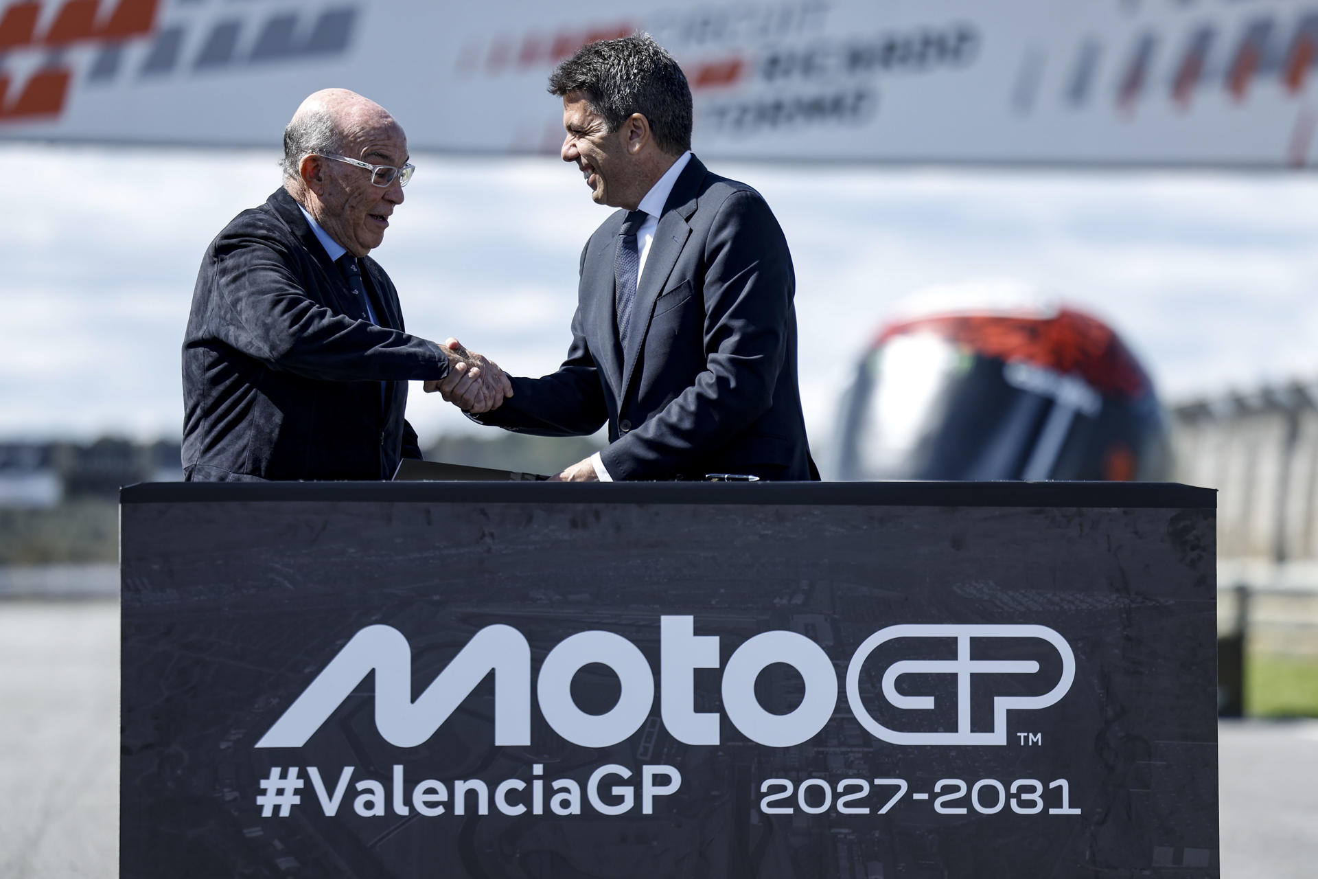 El president de la Generalitat, Carlos Mazón, y el consejero delegado de Dorna, Carmelo Ezpeleta, se estrechan la mano tras anunciar este martes un acuerdo para que el Circuito Ricardo Tormo de Cheste mantenga una de las pruebas de la competición hasta 2031. EFE/Biel Aliño