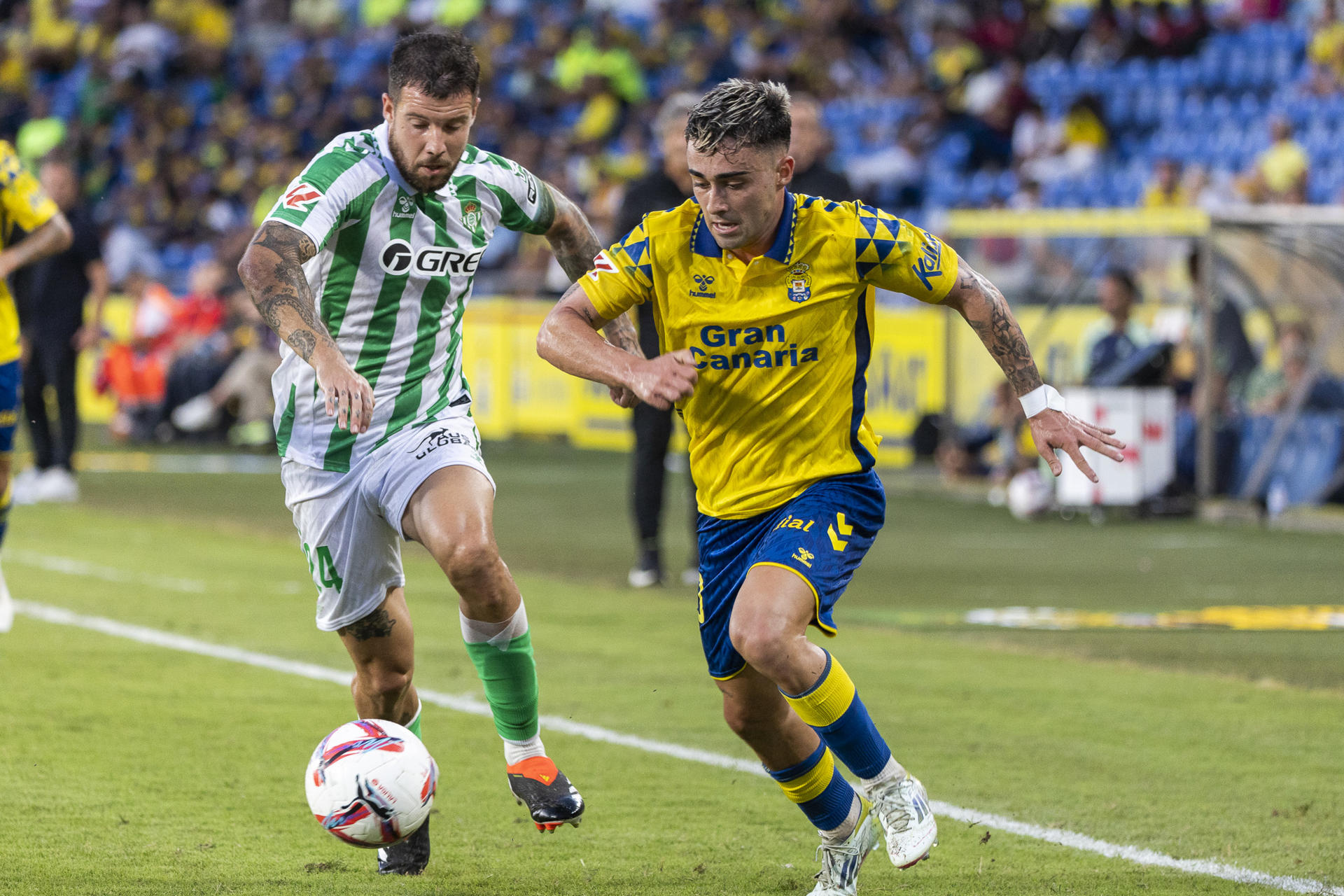 El centrocampista de la UD Las Palmas Alberto Moleiro (d) lucha con Aitor Ruibal, del Betis, en el estadio de Gran Canaria en foto de archivo de Quique Curbelo. EFE