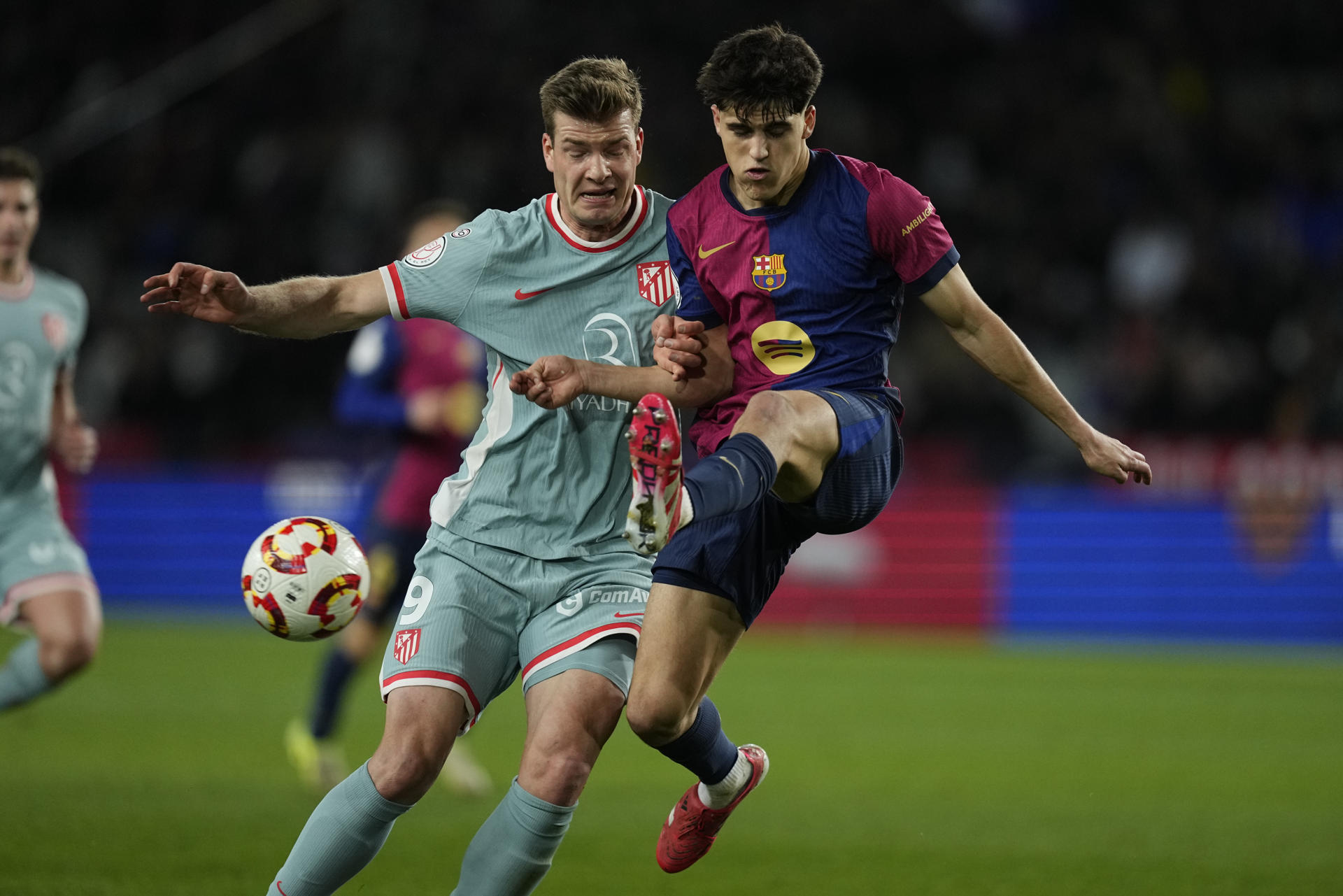 El delantero del Atlético de Madrid Alexander Sørloth (i) lucha con Pau Cubarsí, del Barcelona, durante el partido de ida de las semifinales de la Copa del Rey que midió a ambos conjuntos. EFE/Enric Fontcuberta
