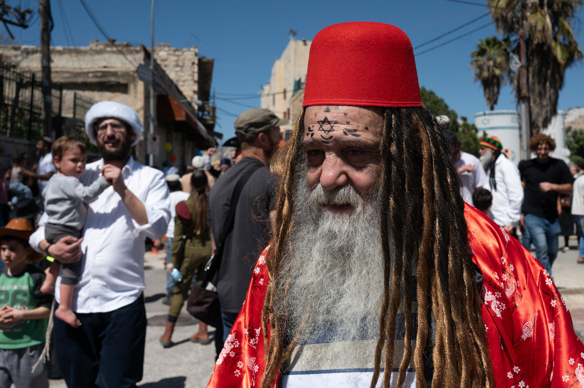 Colonos israelíes recorren las calles de la ciudad palestina de Hebrón, en la Cisjordania ocupada, este domingo durante la celebración de Purim, una de las fiestas más alegres del calendario judío. Conmemora la salvación de los judíos en los tiempos que vivían en Persia. EFE/ Magda Gibelli