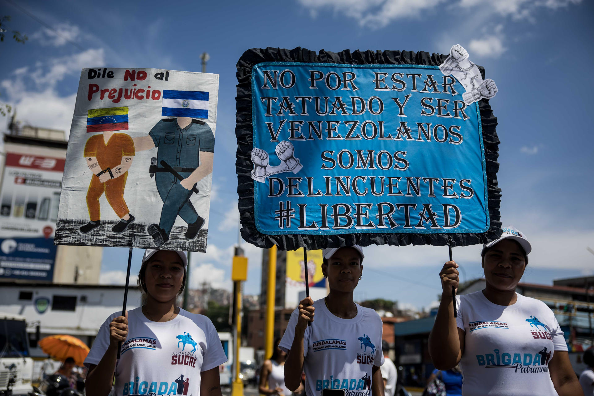 Venezolanos sostienen carteles durante la recolección de firmas en apoyo a sus compatriotas migrantes deportados desde Estados Unidos a El Salvador este viernes, en Caracas (Venezuela). EFE/ Miguel Gutiérrez