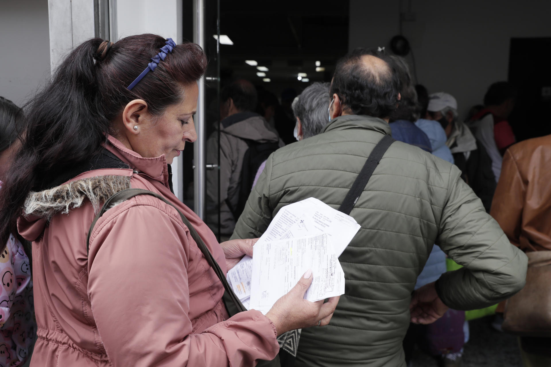 Una mujer hace fila para reclamar medicamentos este viernes, en Bogotá (Colombia). EFE/ Carlos Ortega