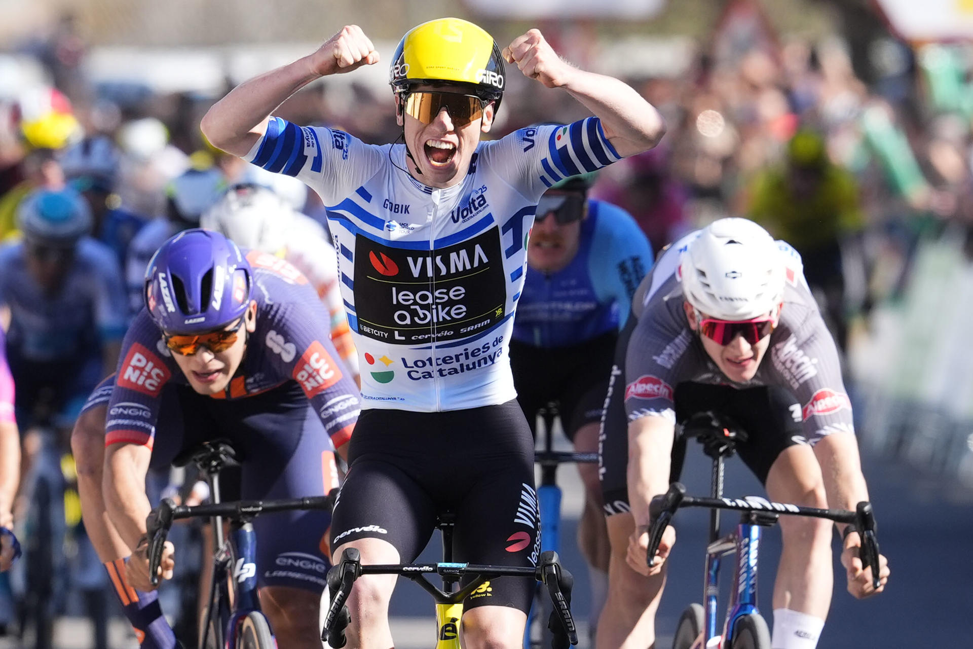 El británico Matthew Brennan (c), del Team Visma, se impone al esprint la quinta etapa de la Volta Ciclista a Catalunya, de 172 kilómetros entre Paüls y Amposta, en las Terres de l'Ebre, tras la que Juan Ayuso (UAE) se convirtió en el nuevo líder de la prueba, con un segundo de ventaja sobre Primoz Roglic (Red Bull), tras bonificar un segundo en un esprint intermedio. EFE/Siu Wu