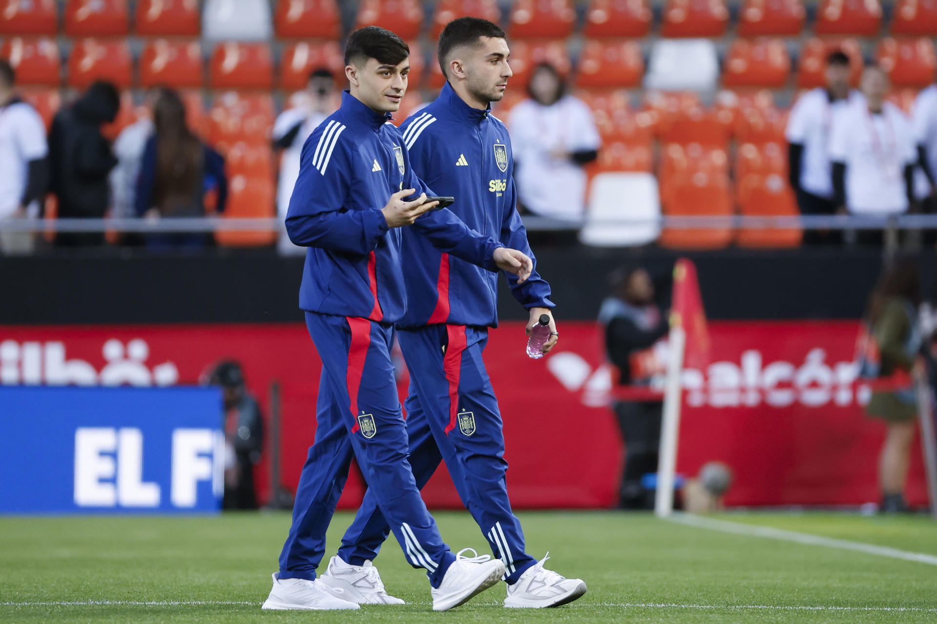 Los jugadores de la selección española Pedri (i) y Ferran Torres (d) caminan por el césped de Mestalla antes del encuentro de vuelta de los cuartos de final de la Liga de Naciones ante Países Bajos, este domingo en Valencia. EFE/ Ana Escobar