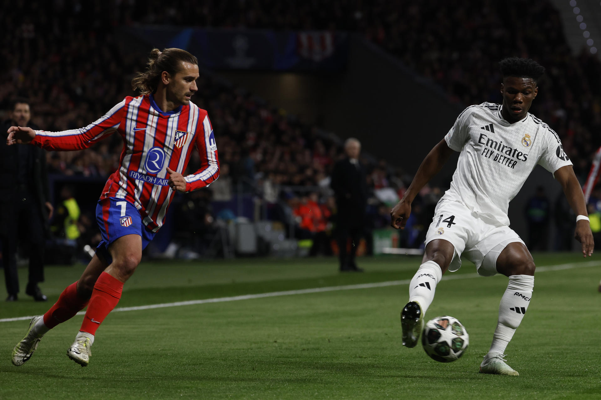 El centrocampista del Madrid Aurélien Tchouaméni (d) controla un balón ante Antoine Griezmann, del Atlético, durante el partido de vuelta de los octavos de final de la Liga de Campeones en el estadio Metropolitano. EFE/Juanjo Guillén