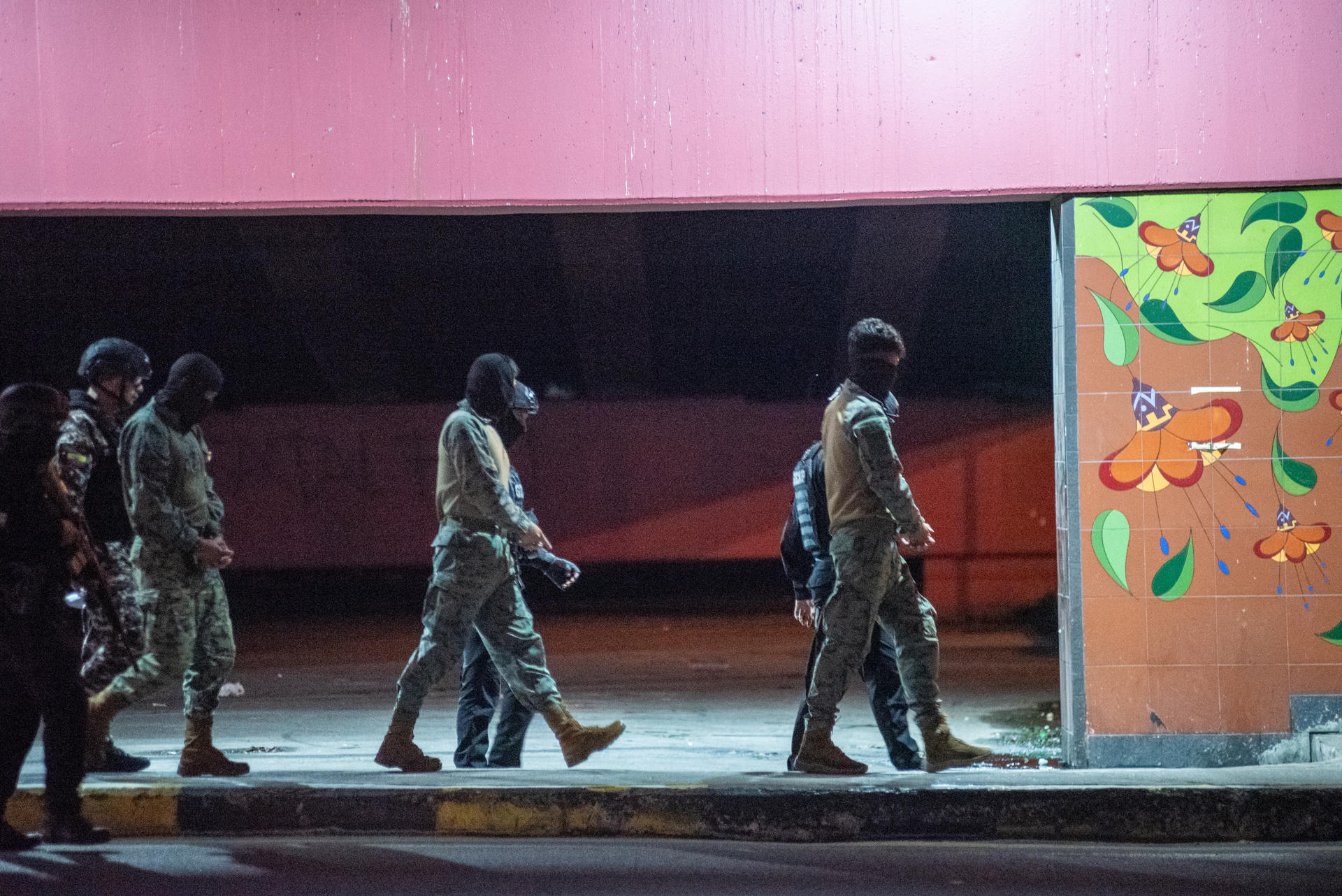 Militares implicados en el asesinato y desaparición de cuatro menores caminan por una zona durante la reconstrucción del caso Las Malvinas, este domingo, en Guayaquil (Ecuador). EFE/ Mauricio Torres