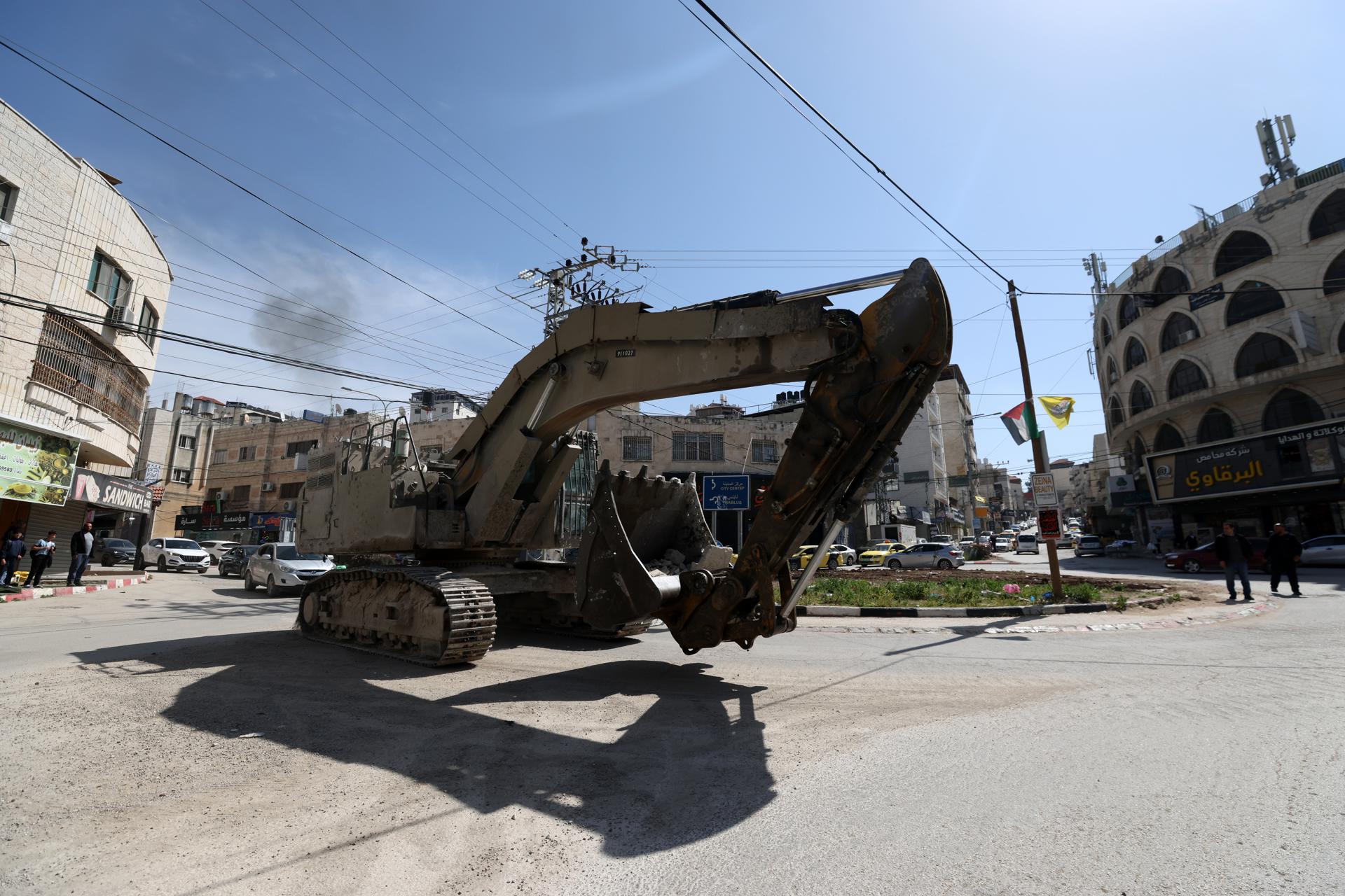 Una excavadora del Ejército israelí pasa por una calle durante una operación militar israelí en la ciudad de Tulkarem, 13 de marzo de 2025. 
EFE/EPA/ALAA BADARNEH