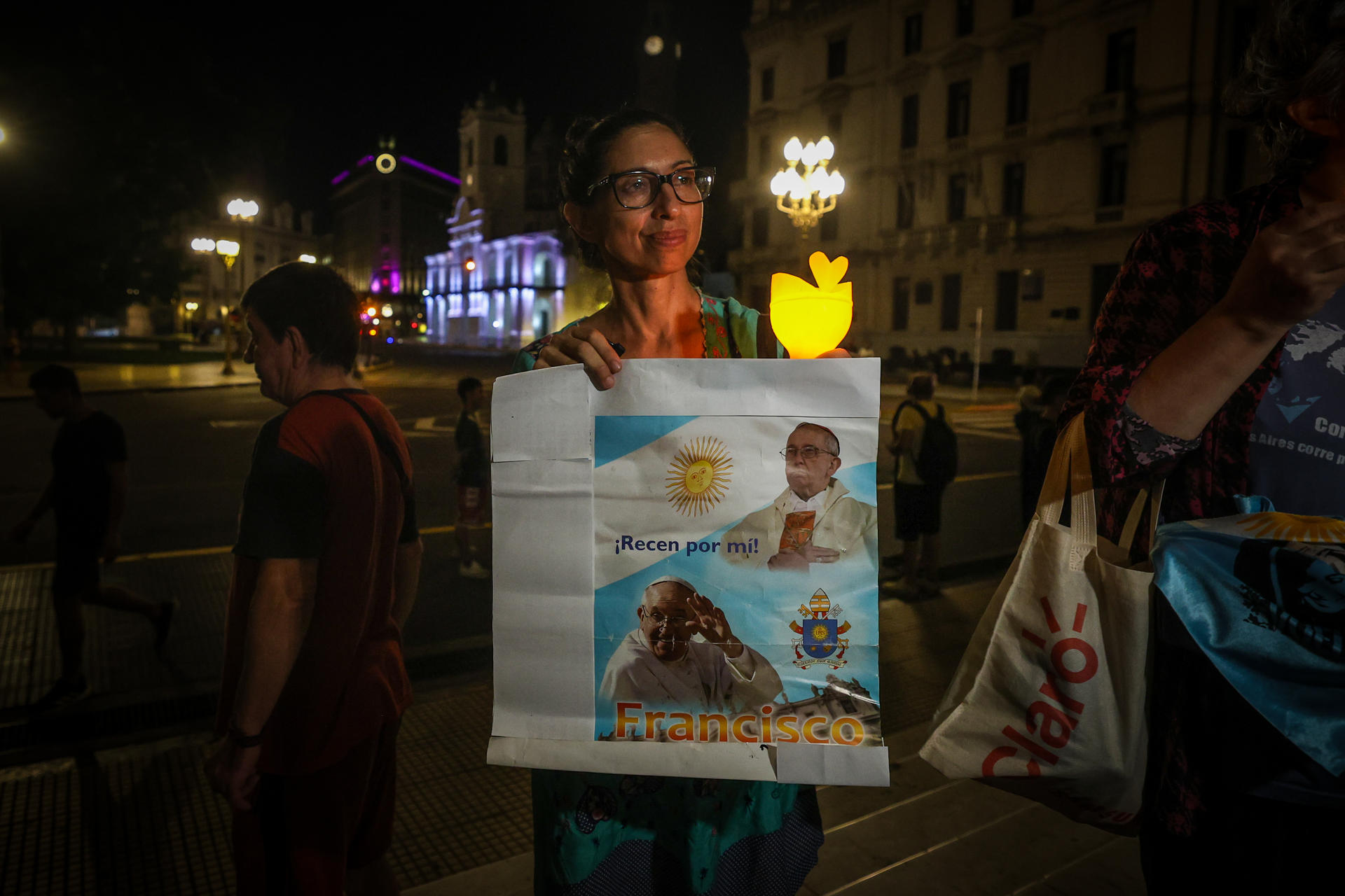 Una mujer sostiene un cartel del Papa Francisco durante una reunión para pedir por su salud frente a la Catedral de Buenos Aires este viernes, en Buenos Aires (Argentina). EFE/Juan Ignacio Roncoroni