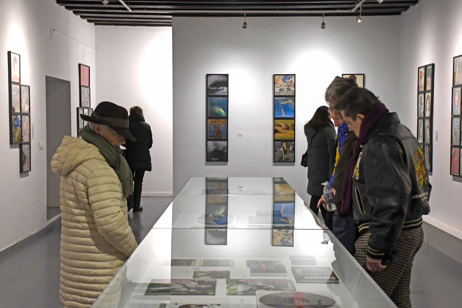 Varios visitantes observan una muestra de la exposición organizada por el Palacio Quintanar de más de 350 carátulas, además de libros, carteles y documentos, que recorren medio siglo de música con diseño de grandes creadores, este viernes en Segovia. EFE/ Pablo Martín