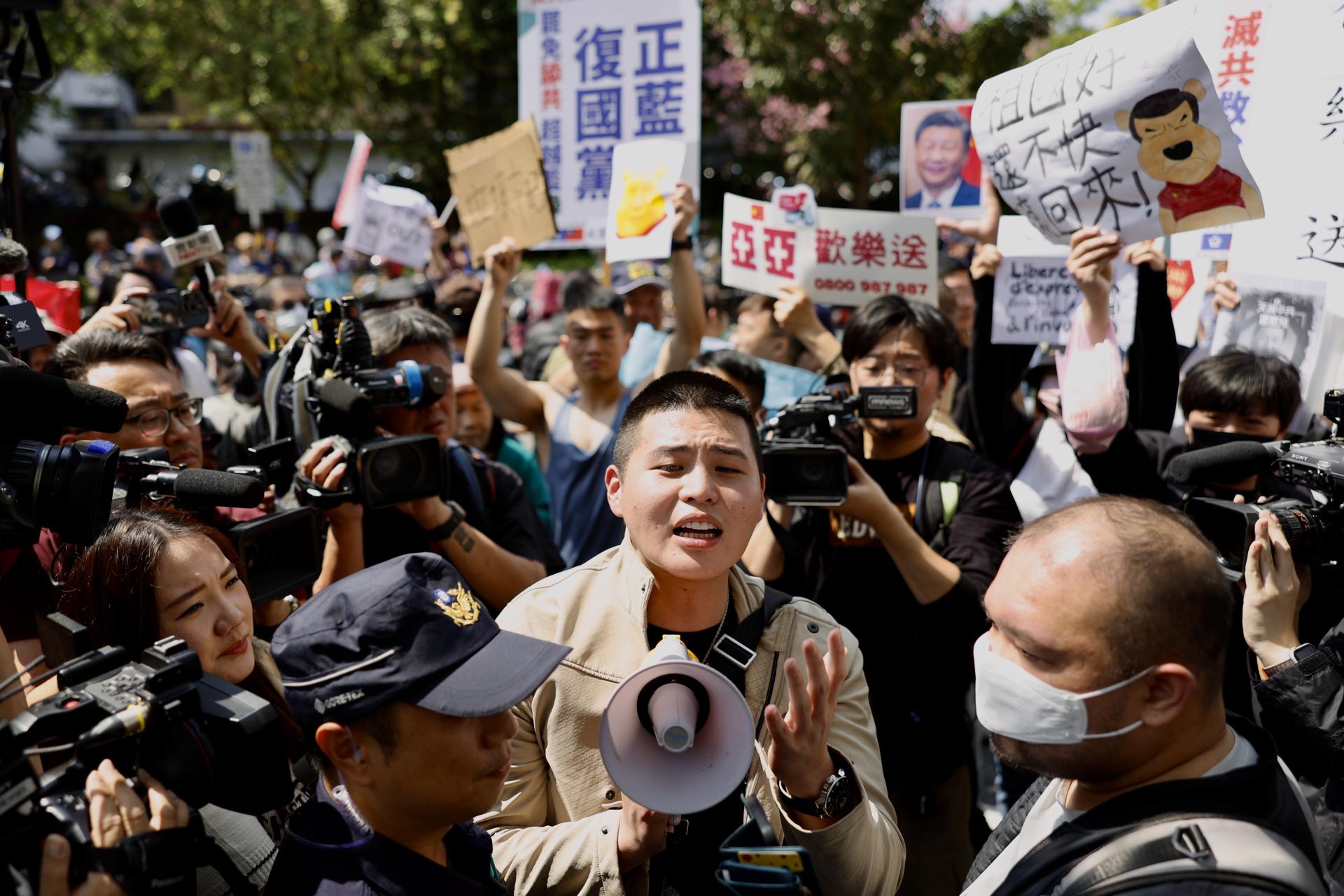 Manifestantes corean consignas contra Liu y exhibien pancartas en rechazo a China durante la rueda de prensa de la 'influencer'. EFE/EPA/RITCHIE B. TONGO