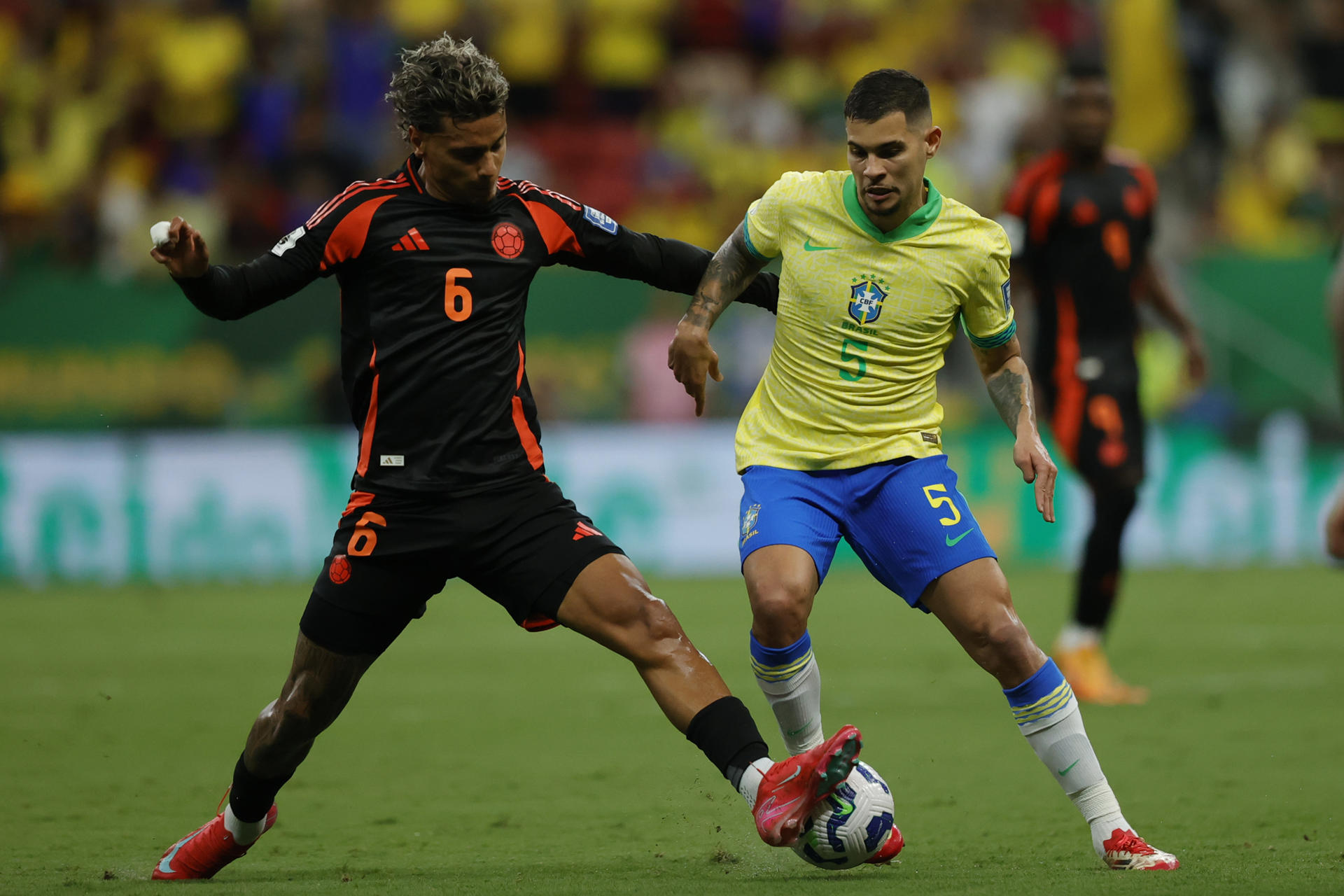 Bruno Guimaraes (d) disputa el balón con el colombiano Richard Ríos durante el partido que enfrentó a Brasil con Colombia en el estadio Mané Garrincha de Brasilia. EFE/ Andre Coelho