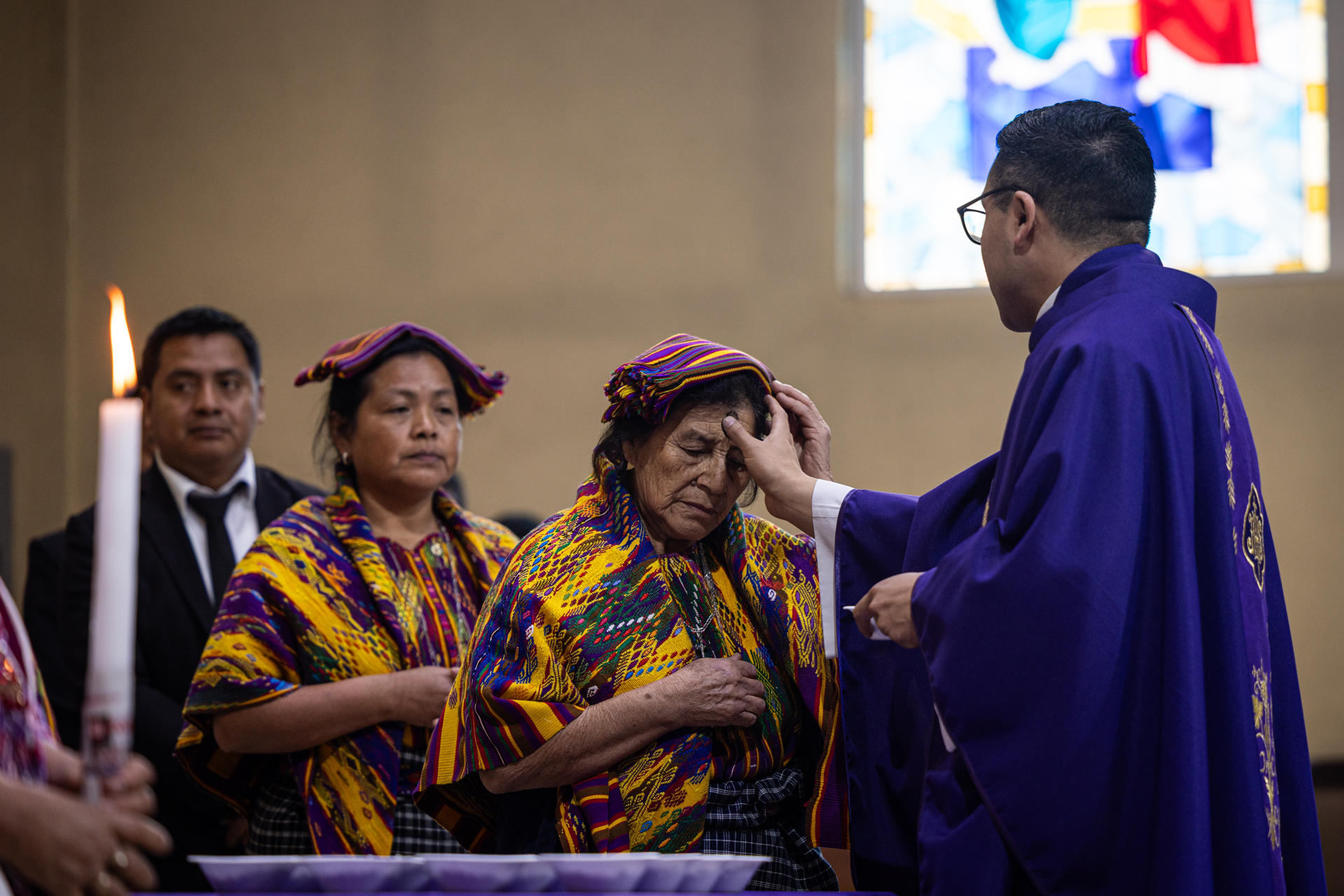 Un sacerdote impone la cruz de ceniza a una mujer del poblado maya kaqchiquel durante el tradicional Miércoles de Ceniza, en la parroquia de San Juan Bautista en San Juan Sacatepéquez (Guatemala). EFE/ David Toro