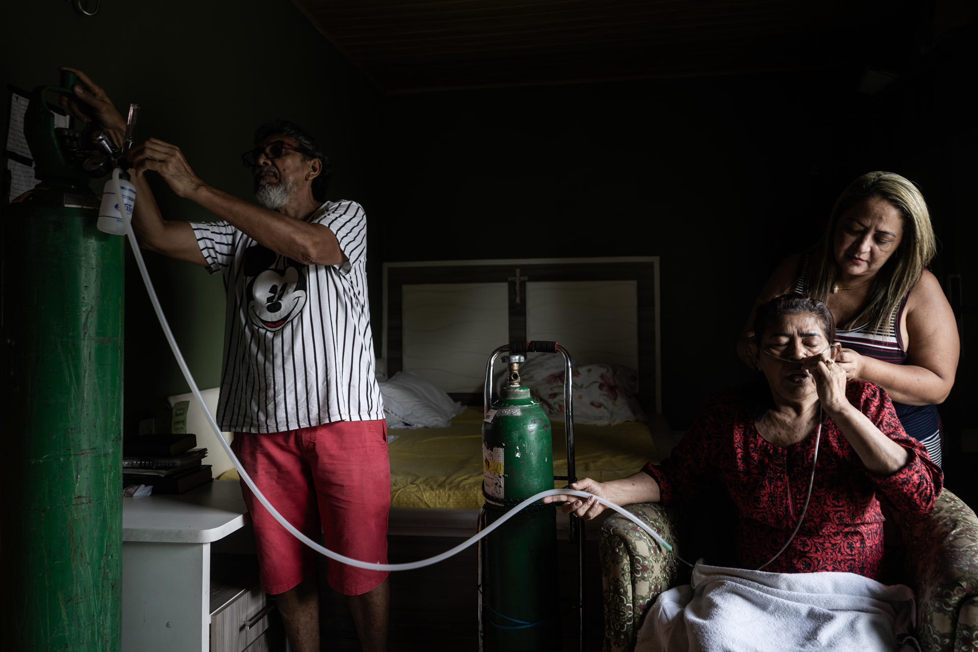Fotografía del 31 de enero de 2025 de Eliana Souza do Nascimento (d-abajo) respirando oxígeno con asistencia de un tanque en su vivienda, en Manaos (Brasil). EFE/ Raphael Alves