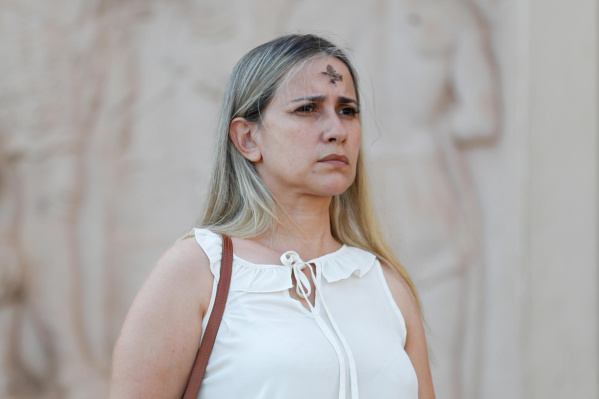 Una mujer camina luego de recibir la cruz de ceniza, durante la celebración del Miércoles de Ceniza en la Catedral Metropolitana Nuestra Señora de la Asunción (Paraguay). EFE/ Juan Pablo Pino