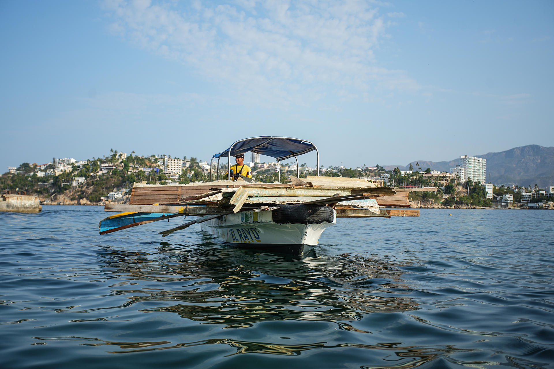 Personal de limpieza a bordo de lanchas retiran basura y escombro este jueves, de las playas de Acapulco en Guerrero (México). EFE/ David Guzmán.
