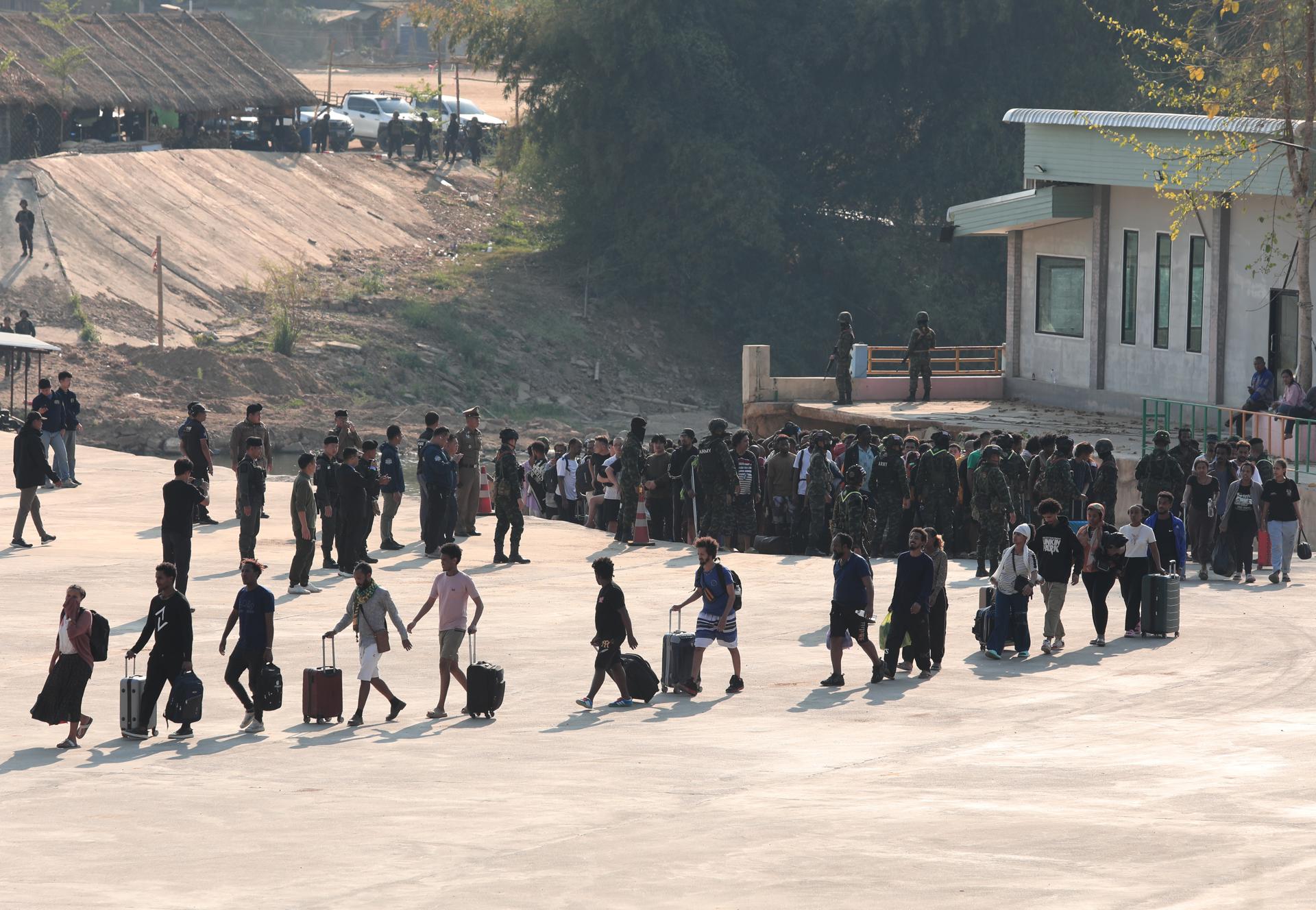 Fotografía de archivo, tomada el 12/02/2025, que muestra a personas rescatadas de centros de estafa en Birmania (Myanmar) cruzando hacia Tailandia para ser posteriormente repatriadas a sys lugares de origen. EFE/EPA/SOMRERK KOSOLWITTHAYANANT