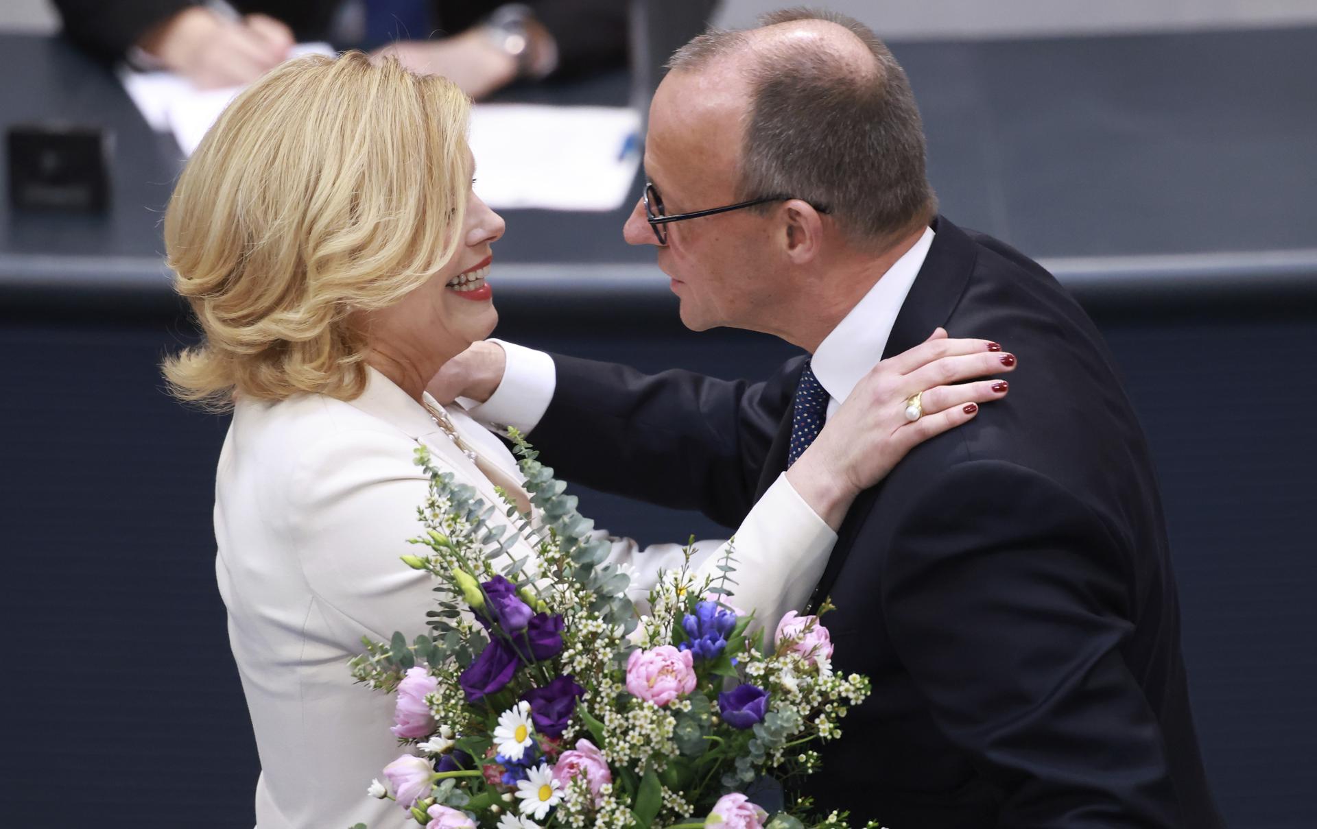 La nueva presidenta del Bundestag, Julia Kloeckner (I), recibe flores del presidente del partido y de la fracción de la Unión Cristianodemócrata (CDU), Friedrich Merz (D), durante la sesión constitutiva del parlamento alemán 'Bundestag' en Berlín, Alemania, el 25 de marzo de 2025. El 21.º Bundestag alemán celebra su primera sesión constitutiva tras las elecciones generales del 23 de febrero. (Elections, Germany) EFE/EPA/CLEMENS BILAN
