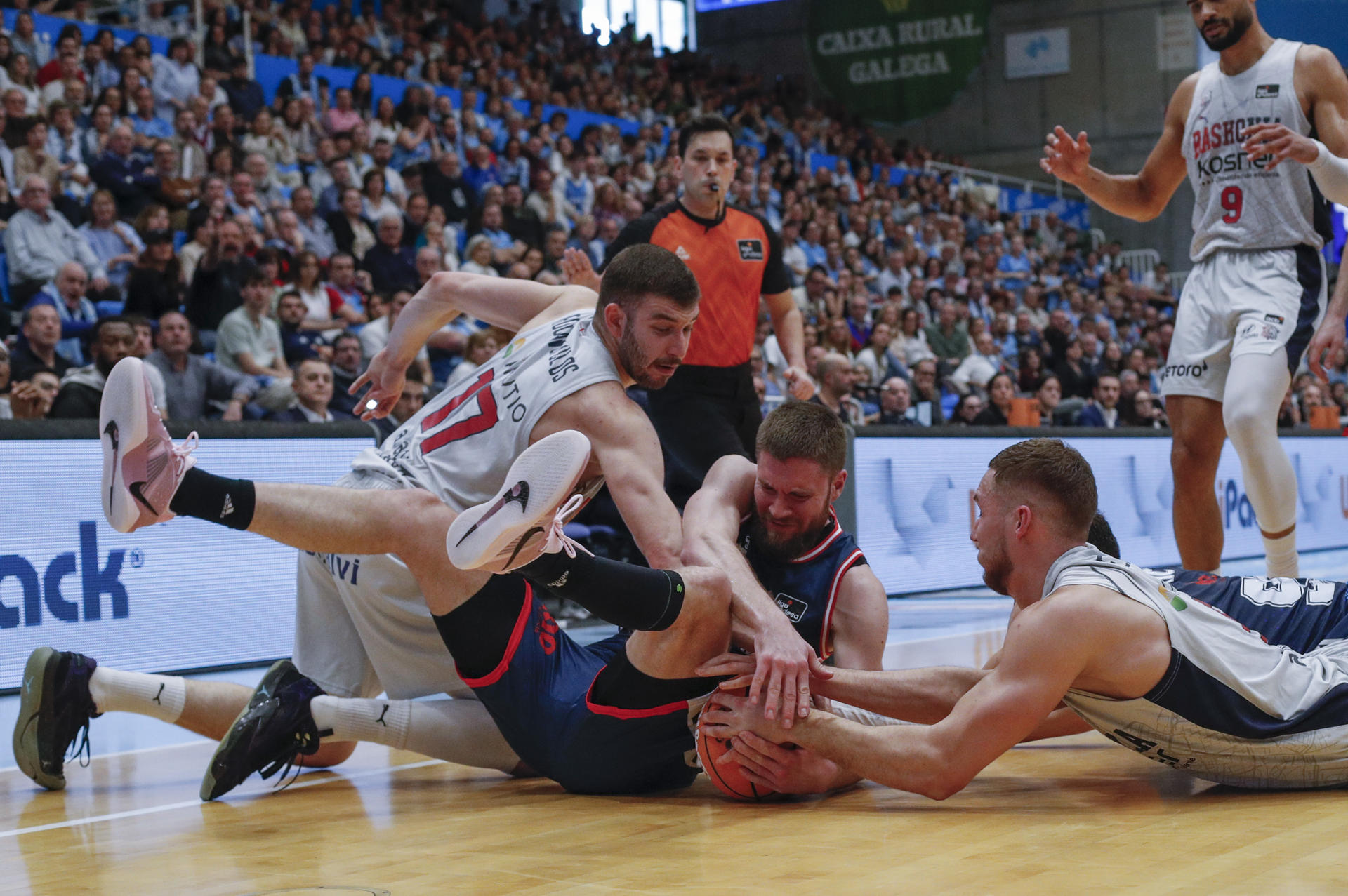 Los jugadores del Baskonia y el jugador del Río Breogán D. Mavra, pelean una pelota durante el partido de la jornada 25 de la Liga Endesa de Baloncesto, este domingo en el Pazo Provincial dos Deportes de Lugo.- EFE/Eliseo Trigo