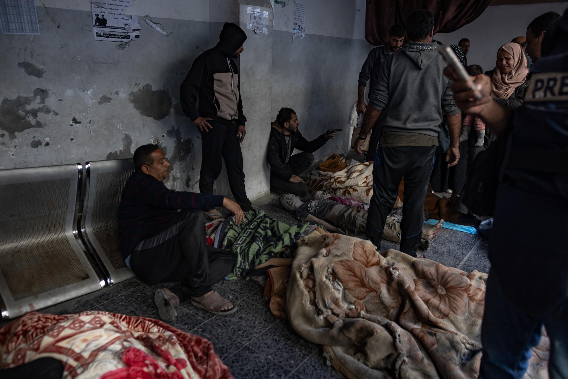 Vecinos y familiares custodian los cuerpos sin vida de las víctimas civiles de los bombardeos israelíes en el Hospital Al-Maadani de la Ciudad de Gaza, 18 de marzo de 2025. 
EFE/EPA/HAITHAM IMAD