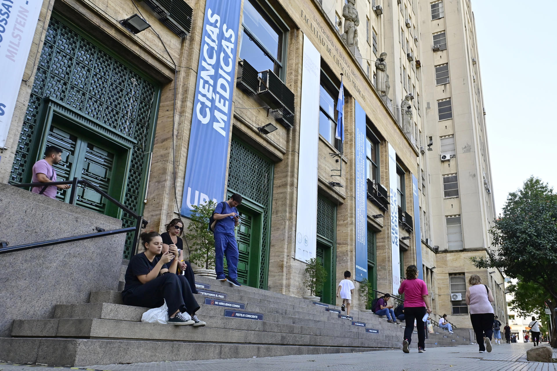 Personas descansan frente a la Facultad de Medicina de la Universidad de Buenos Aires (UBA) este lunes, en Buenos Aires (Argentina). EFE/ Matías Martin Campaya
