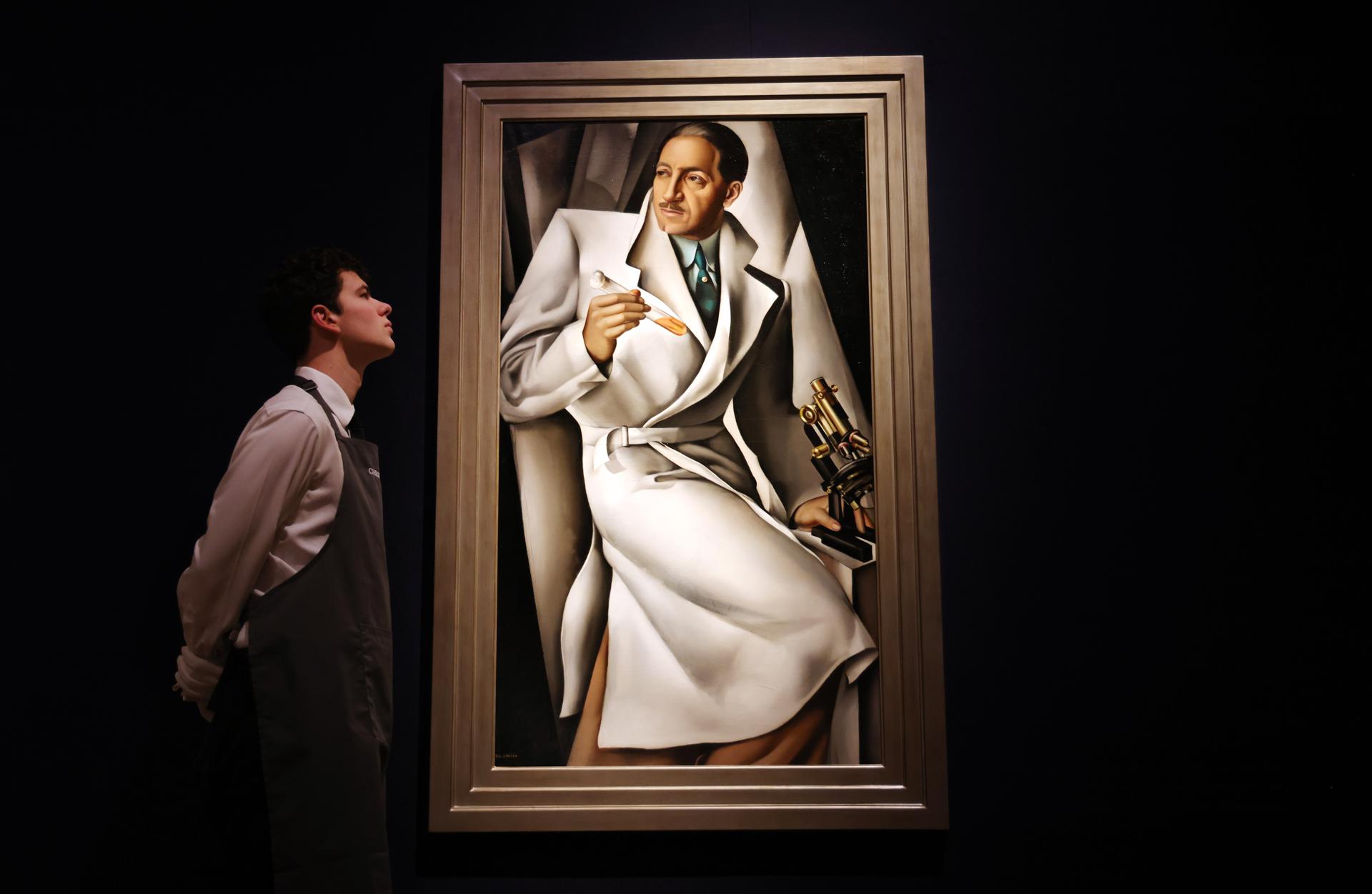 Un personal de Christie's con el 'Portrait du Doctour Bouchard' de Tamara de Lempicka durante una vista previa de la venta de Christie's de los siglos XX y XXI en la casa de subastas Christie's en Londres, Gran Bretaña, el 27 de febrero de 2025. EFE/EPA/Andy Rain
