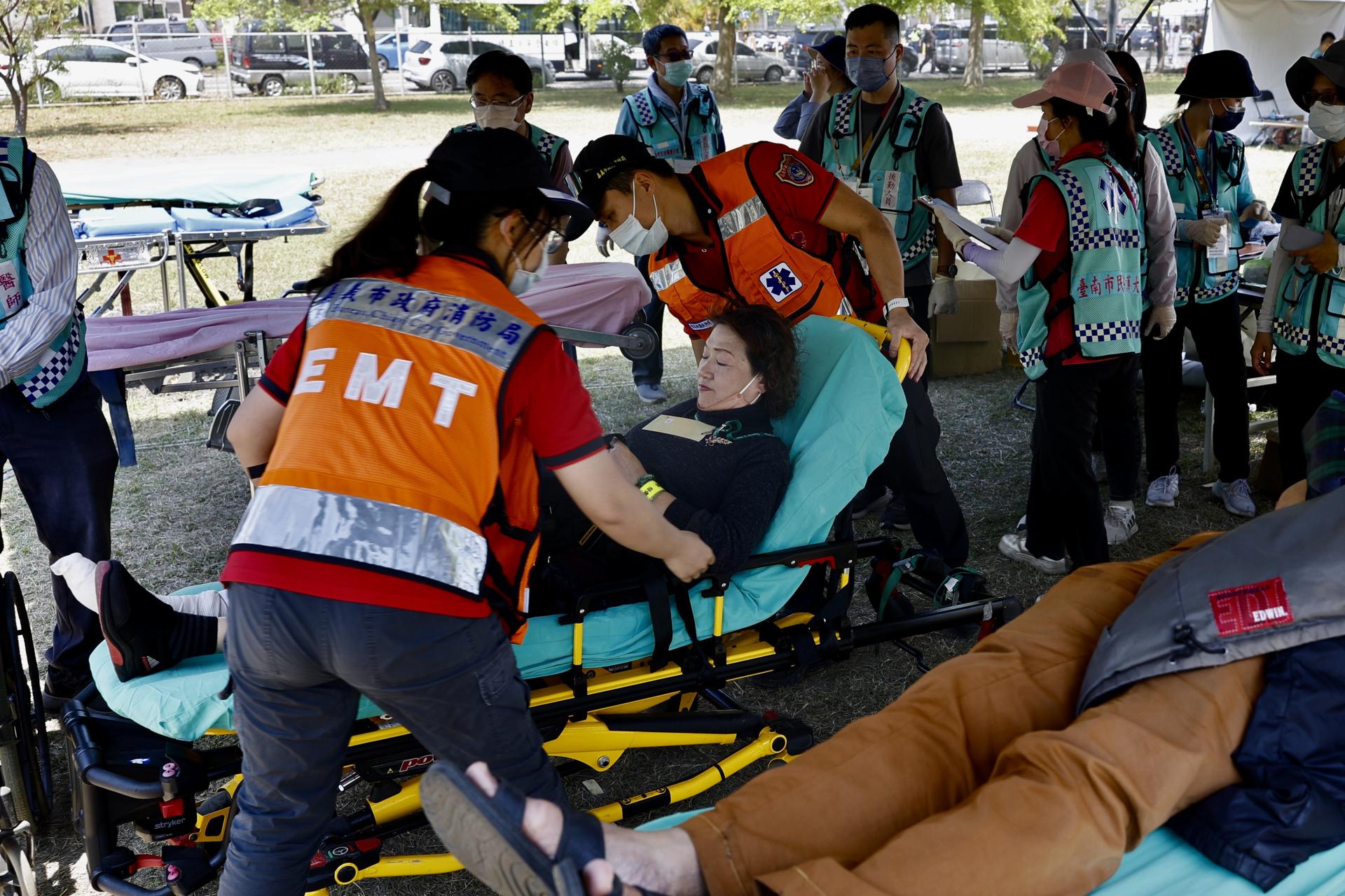 Los participantes atienden a una víctima simulada durante el simulacro de defensa civil en la ciudad de Tainan, en el sur de Taiwán, el 27 de marzo de 2025. EFE/EPA/RITCHIE B. TONGO