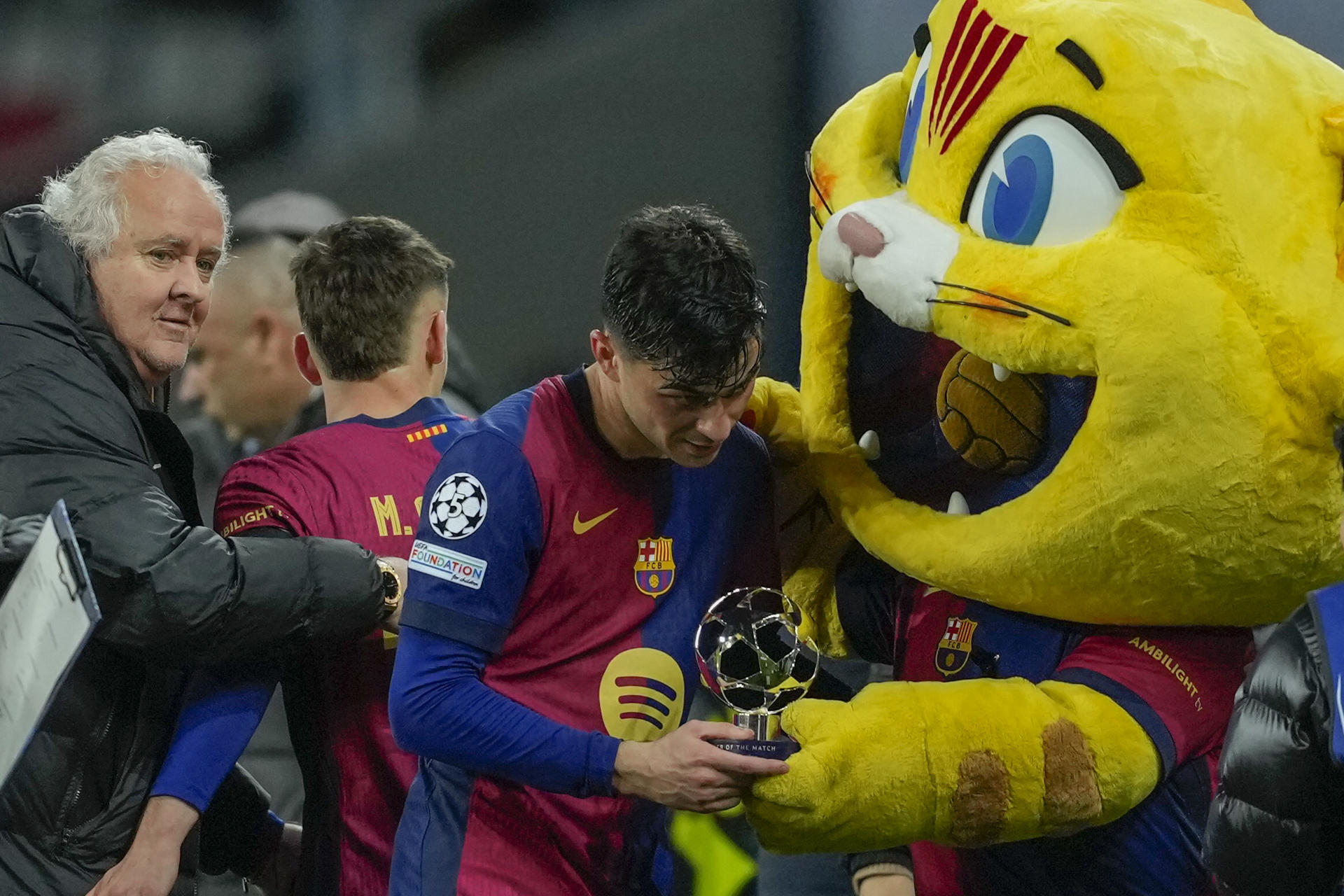 El centrocampista del Barcelona Pedri recibe el trofeo de mejor jugador del encuentro tras el partido de vuelta de los octavos de final de la Liga de Campeones que FC Barcelona y SL Benfica disputaron este martes en el Estadi Olímpic Lluís Companys. EFE/Alejandro García