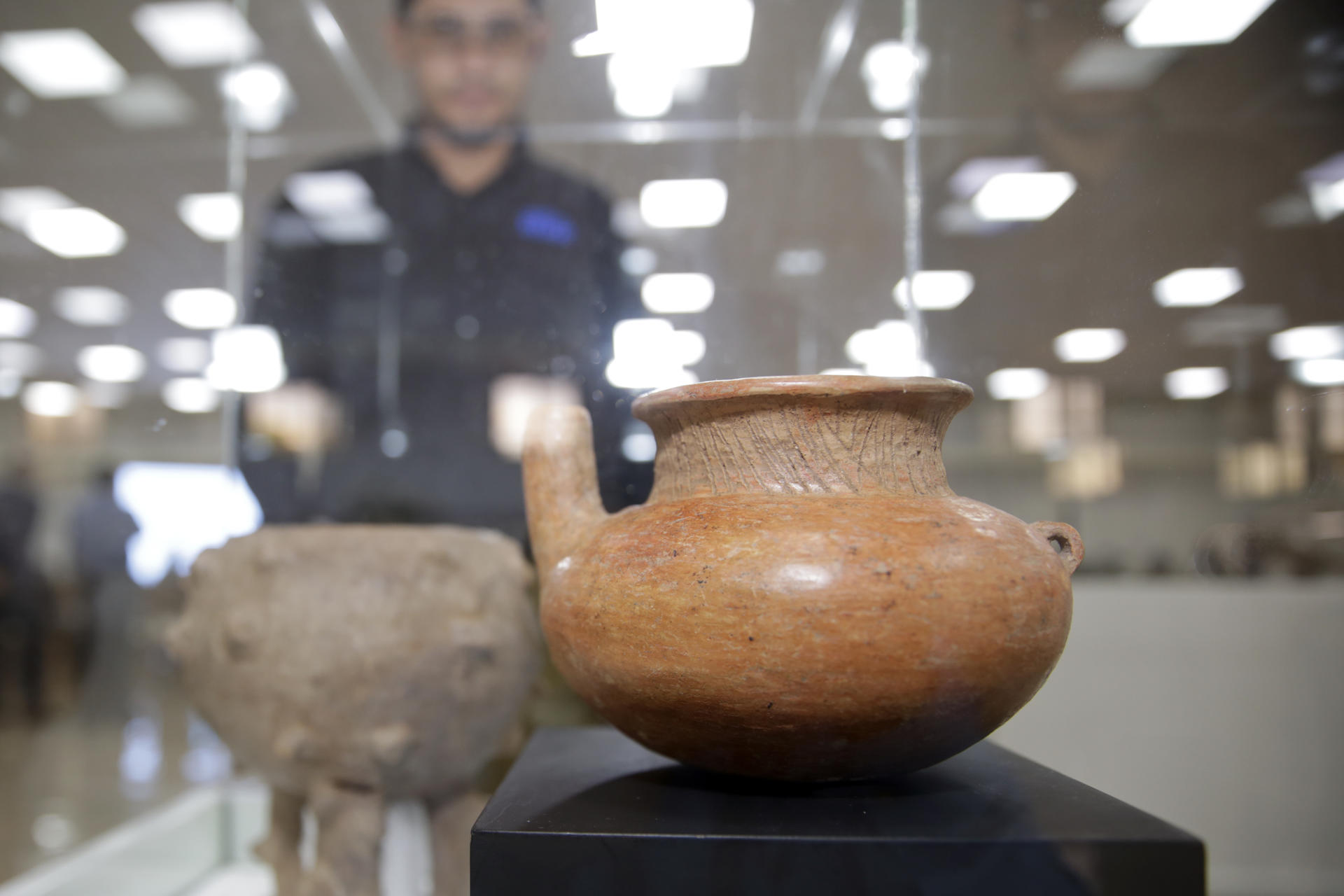 Una persona fue registrada este miércoles, 19 de marzo, al observar una de las 133 piezas arqueológicas devueltas por el Museo Quai Branly de Francia a la Secretaría de Relaciones Exteriores y Cooperación Internacional de Honduras, en Tegucigalpa (Honduras). EFE/Gustavo Amador