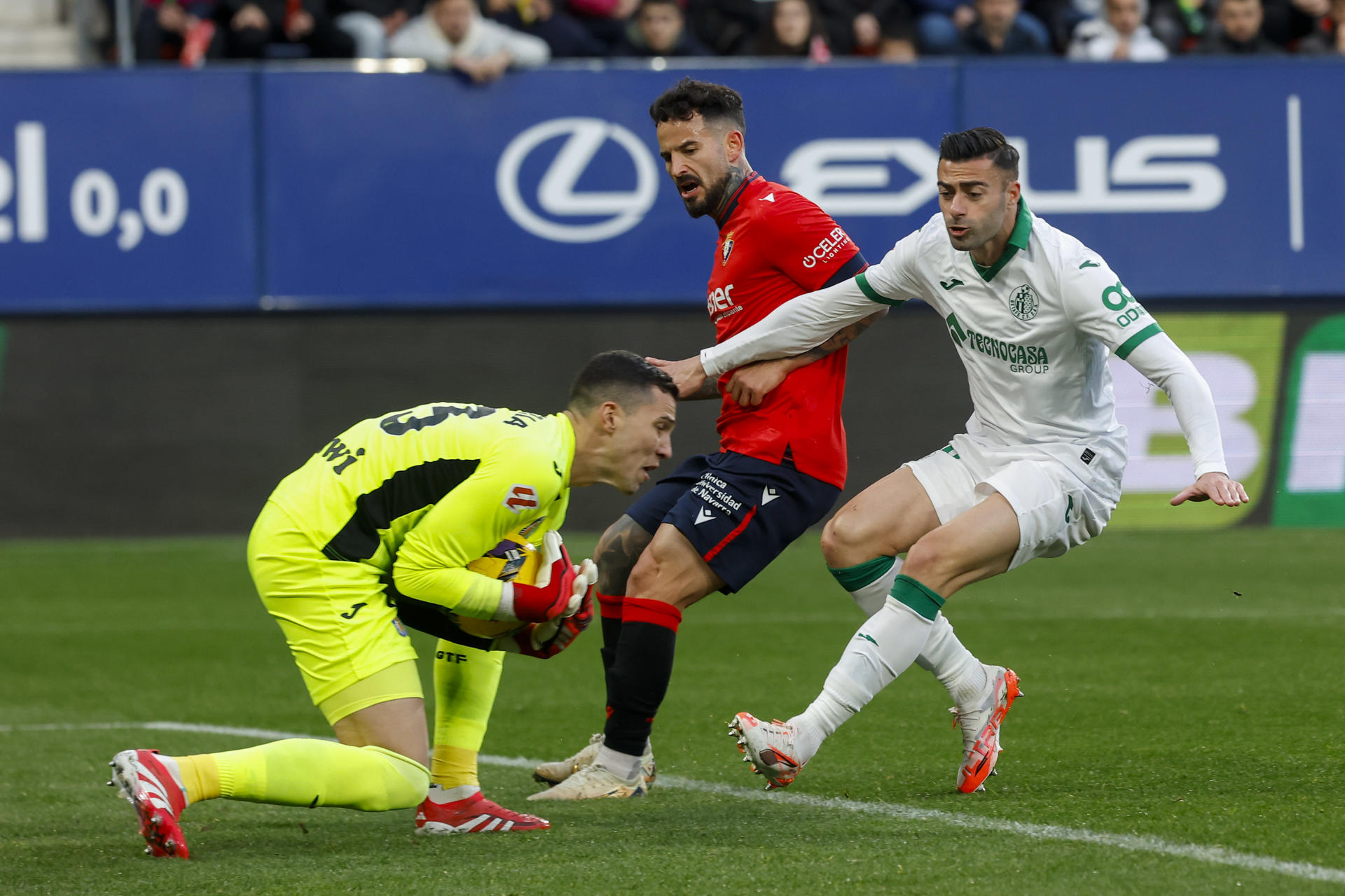 El portero del Getafe David Soria (i) atrapa el balón durante el partido de LaLiga entre el Osasuna y el Getafe, en el estadio de El Sadar. EFE/ Villar Lopez