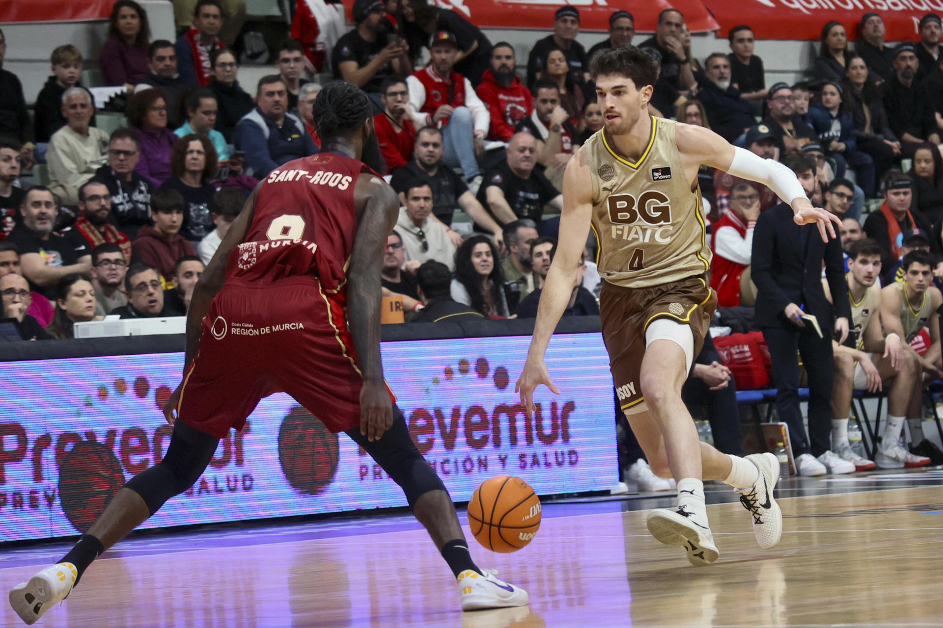 El escolta de Basquet Girona, Pepe Busquets (d), con el balón ante el alero cubano de UCAM Murcia, Howard Sant-Roos, durante el encuentro correspondiente a la fase regular de la Liga Endesa que disputaron en el Palacio de los Deportes de Murcia. EFE/Juan Carlos Caval.