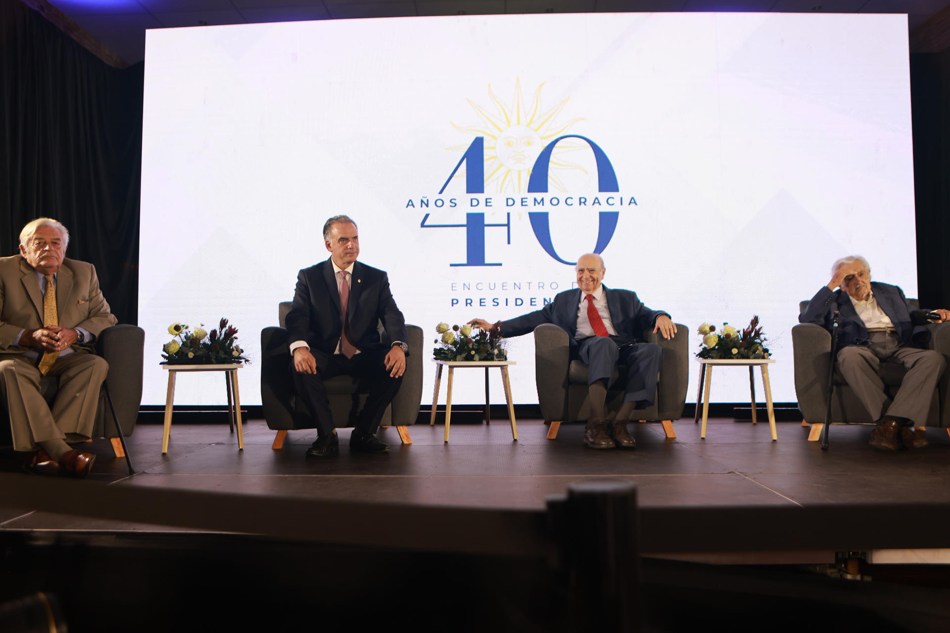 El presidente de Uruguay, Yamandú Orsi (2i), y los exmandatarios uruguayos José Mujica (d), Julio María Sanguinetti (d2) y Luis Lacalle Herrera (i), participan en un encuentro que el opositor Partido Colorado organiza para conmemorar los 40 años de democracia en el país este jueves, en Montevideo (Uruguay). EFE/ Gastón Britos