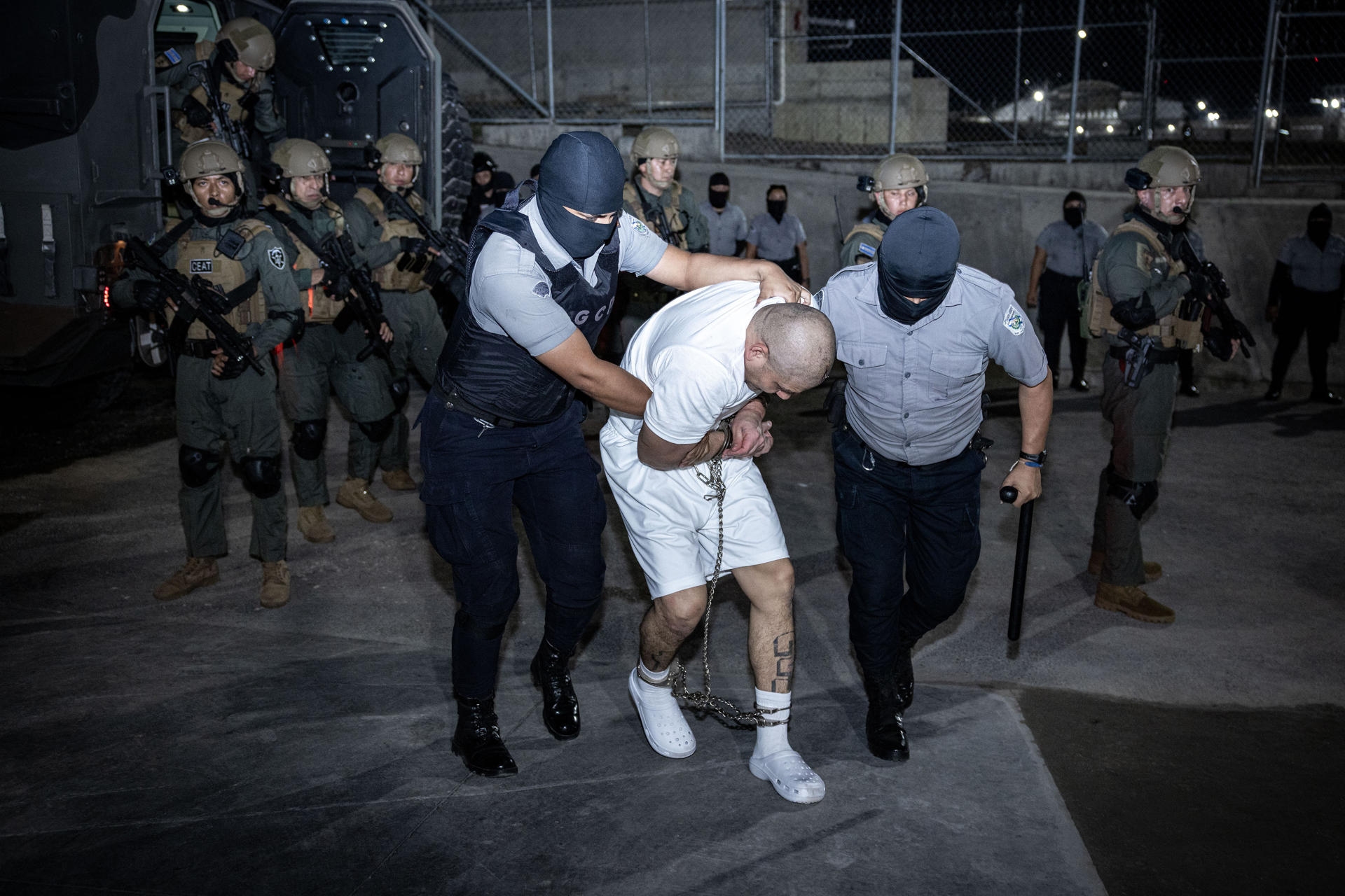 Fotografía cedida este lunes, 17 de marzo, por la Presidencia de El Salvador en la que se registró a un grupo de guardias del Centro de Confinamiento del Terrorismo (Cecot), al ingresar a esta cárcel a un presunto miembro de la banda criminal transnacional Tren de Aragua, en Tecoluca (El Salvador). EFE/Presidencia de El Salvador