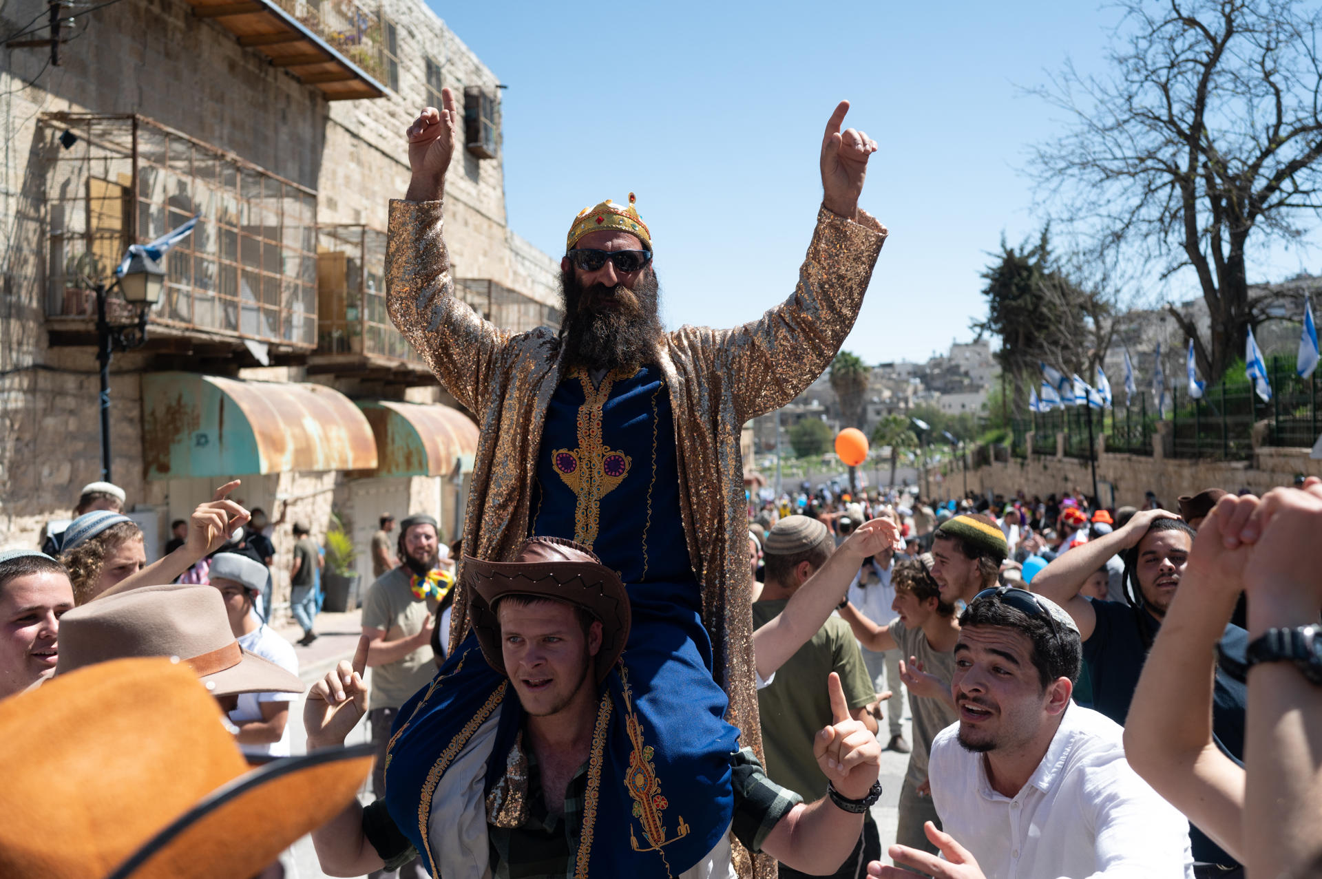 Colonos israelíes recorren las calles de la ciudad palestina de Hebrón, en la Cisjordania ocupada, este domingo durante la celebración de Purim, una de las fiestas más alegres del calendario judío. Conmemora la salvación de los judíos en los tiempos que vivían en Persia. EFE/ Magda Gibelli
