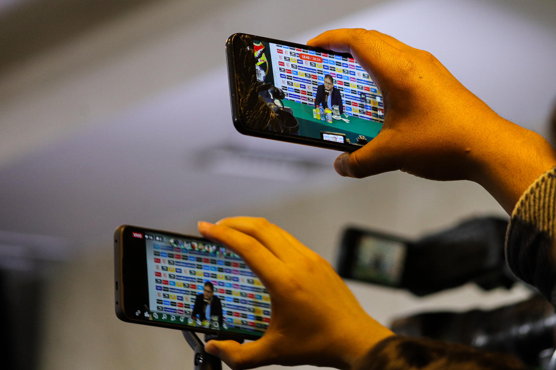 Personas graban con sus teléfonos celulares al seleccionador de Bolivia, Óscar Villegas, durante una conferencia de prensa en La Paz (Bolivia). EFE/ Gabriel Márquez