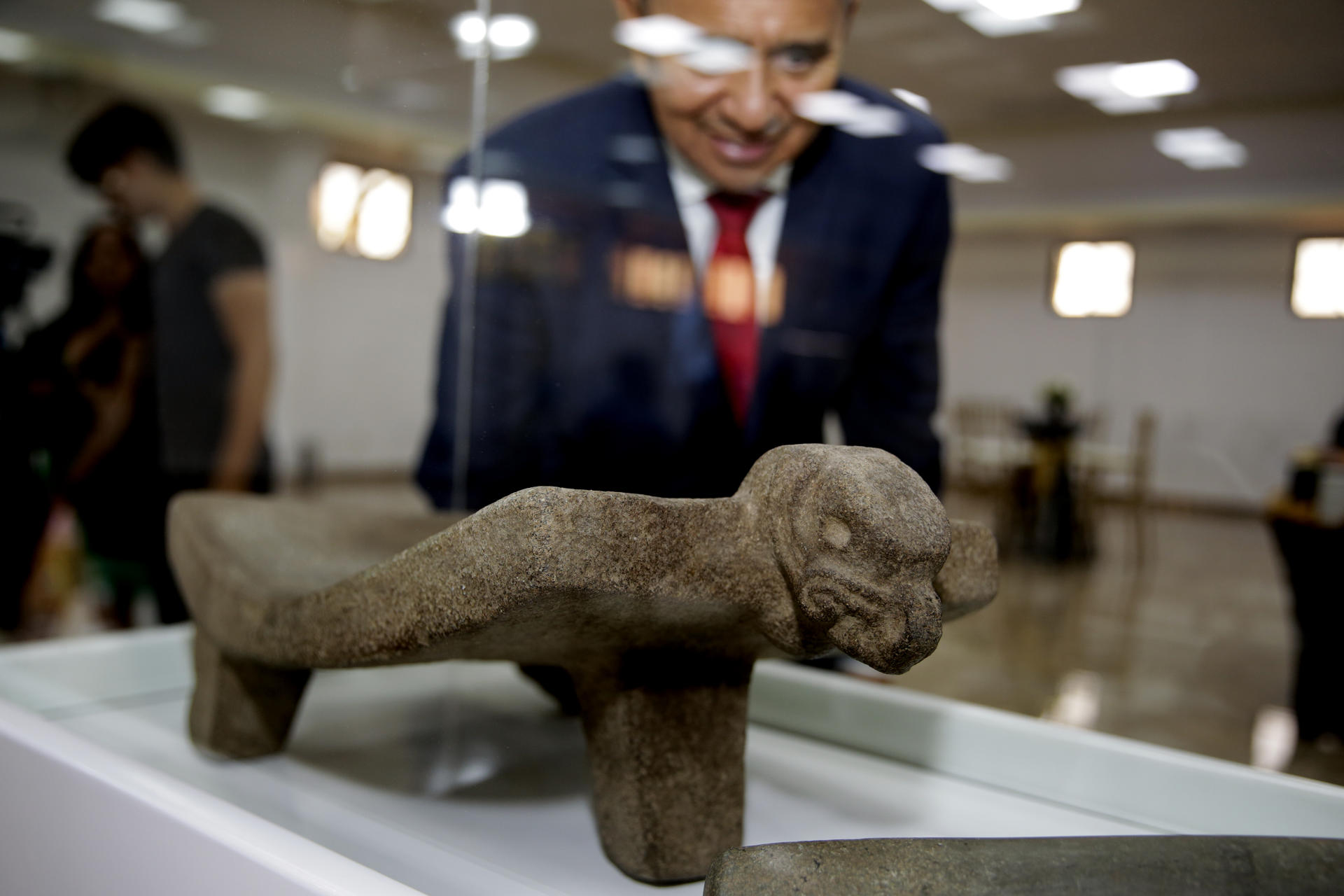 Una persona fue registrada este miércoles, 19 de marzo, al observar una de las 133 piezas arqueológicas devueltas por el Museo Quai Branly de Francia a la Secretaría de Relaciones Exteriores y Cooperación Internacional de Honduras, en Tegucigalpa (Honduras). EFE/Gustavo Amador