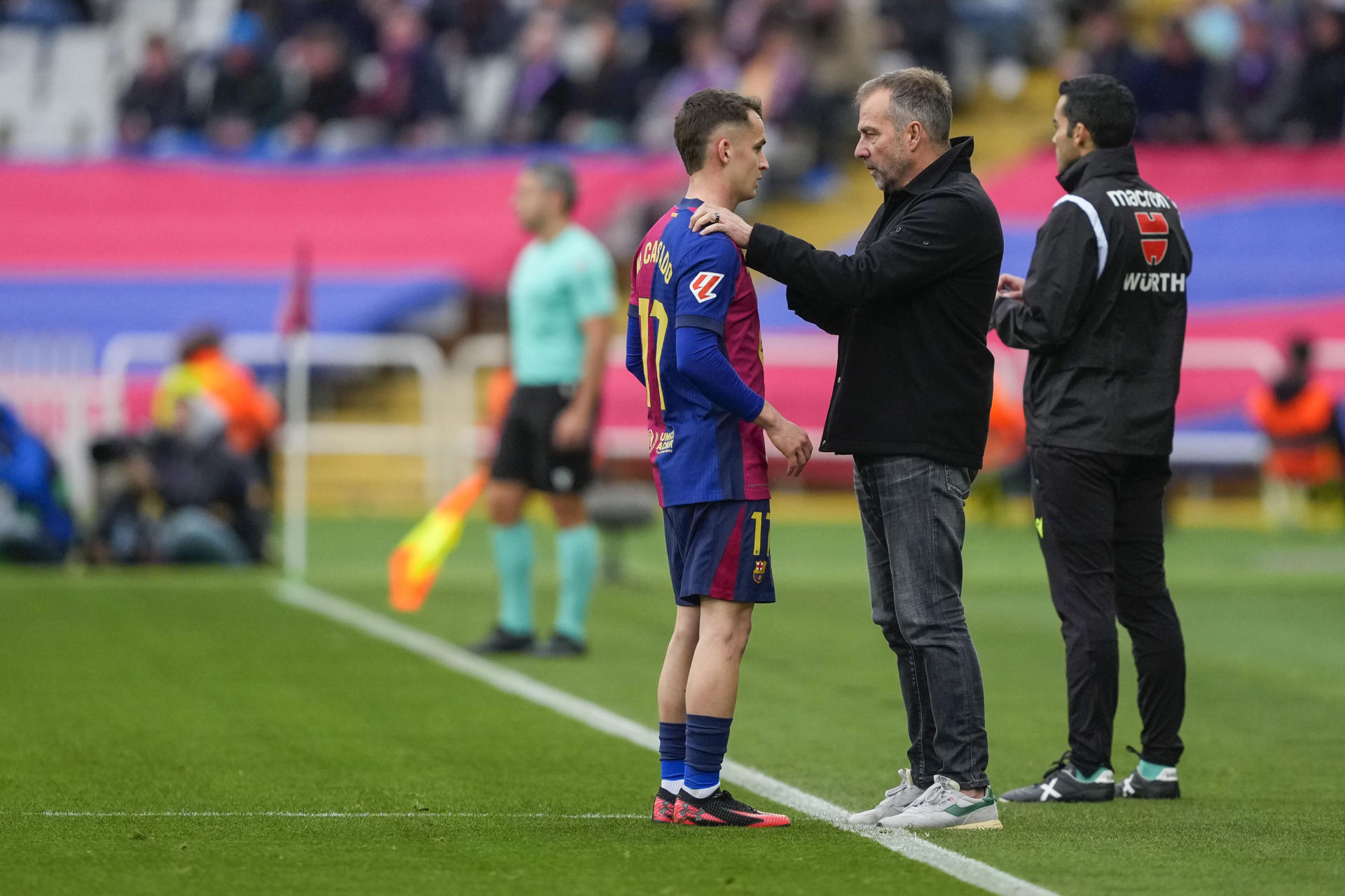 El entrenador del FC Barcelona, Hansi Flick (c), da instrucciones al centrocampista Marc Casadó (i) . en foto de archivo de Alejandro García. EFE