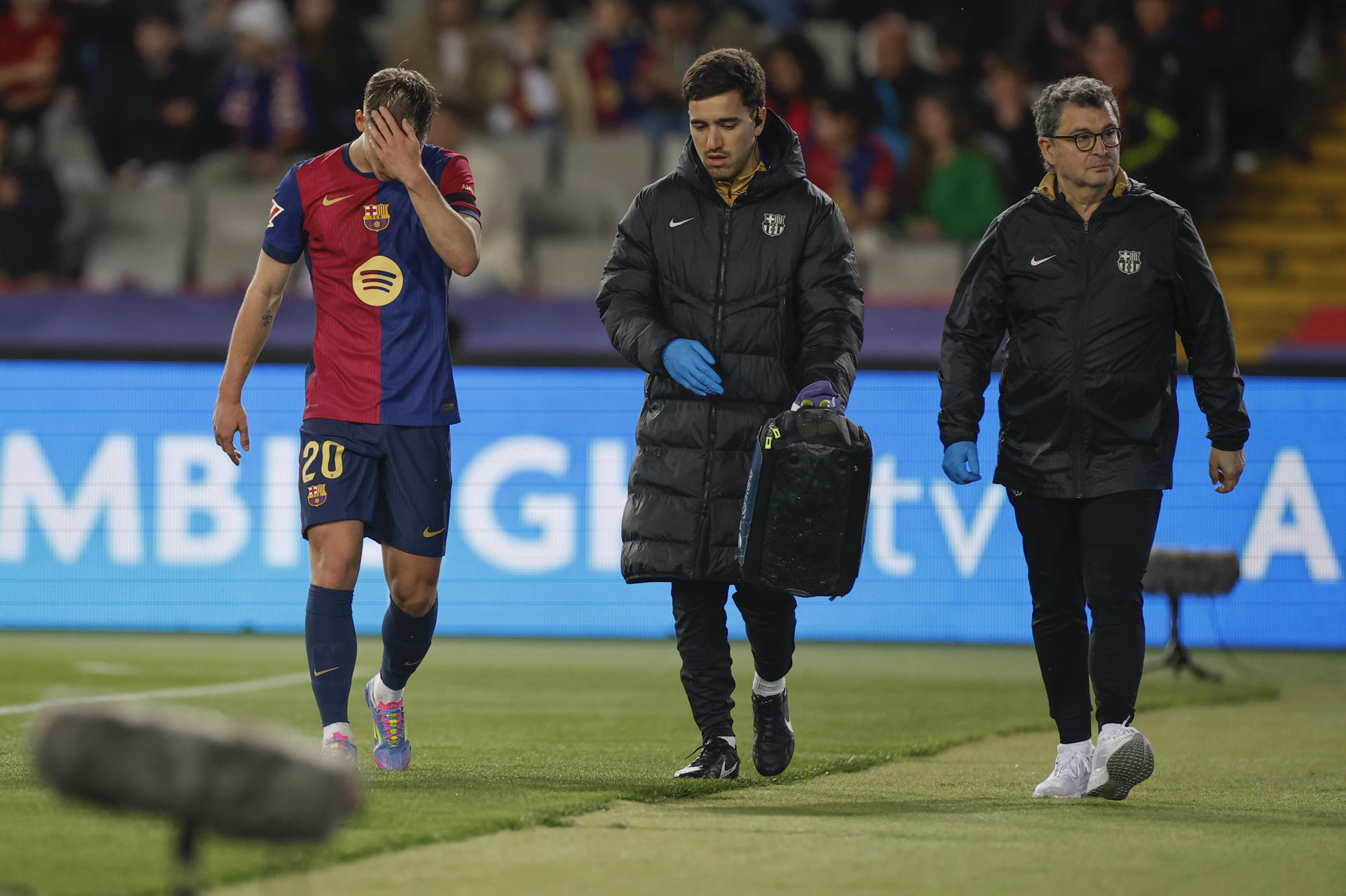 El delantero del F.C. Barcelona Dani Olmo sale del campo por posible lesión durante el partido de LaLiga entre FC Barcelona y CA Osasuna en el Estadio Olímpico de Montjuic, este jueves en Barcelona. EFE/ Alberto Estévez