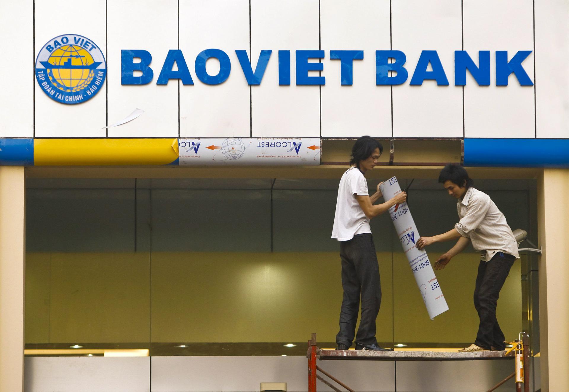 Fotografía de archivo, tomada el 18/2/2009, que muestra a trabajadores colocando un rótulo corporativo en una sucursal del banco Bao Viet Bank en Hanoi, Vietnam. EFE/Dai Kurokawa