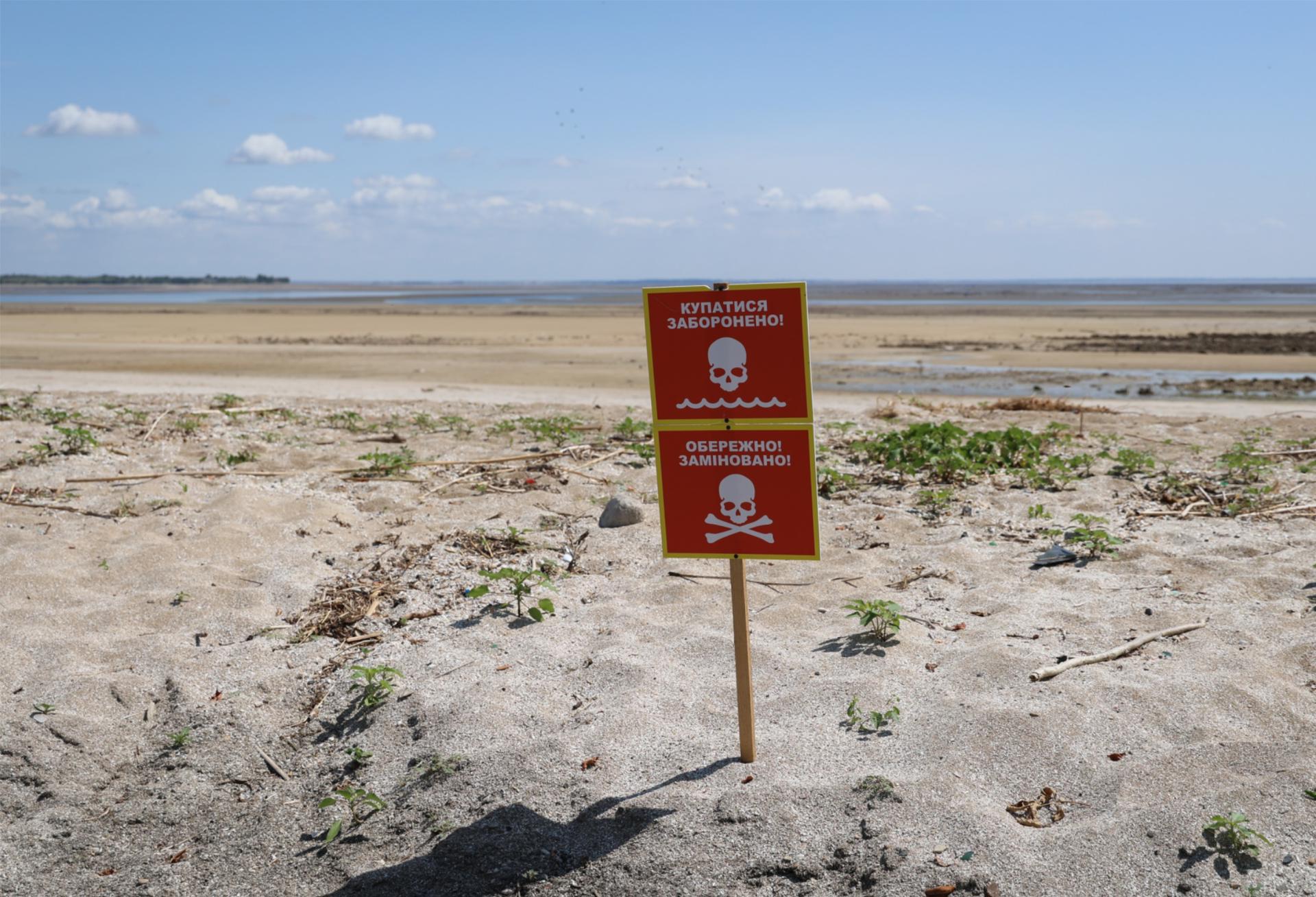 Vista del fondo del antiguo embalse de Kajovka, cerca del pueblo de Novovorontsovka. En el cartel está escrito: ¡Prohibido nadar! ¡Atención Minas!. EFE/Crédito: Ivan Antipenko /Imagen cedida por Science/SOLO USO EDITORIAL