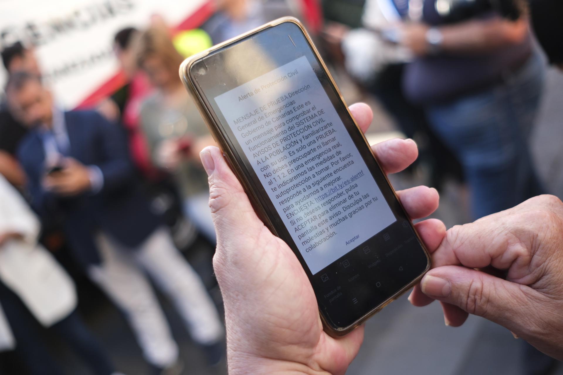 Una persona revisa su teléfono móvil después de recibir una alerta del servicio ES-Alert realizada a modo de prueba del sistema de avisos de emergencias a la población, en una imagen de archivo. EFE/Alberto Valdés