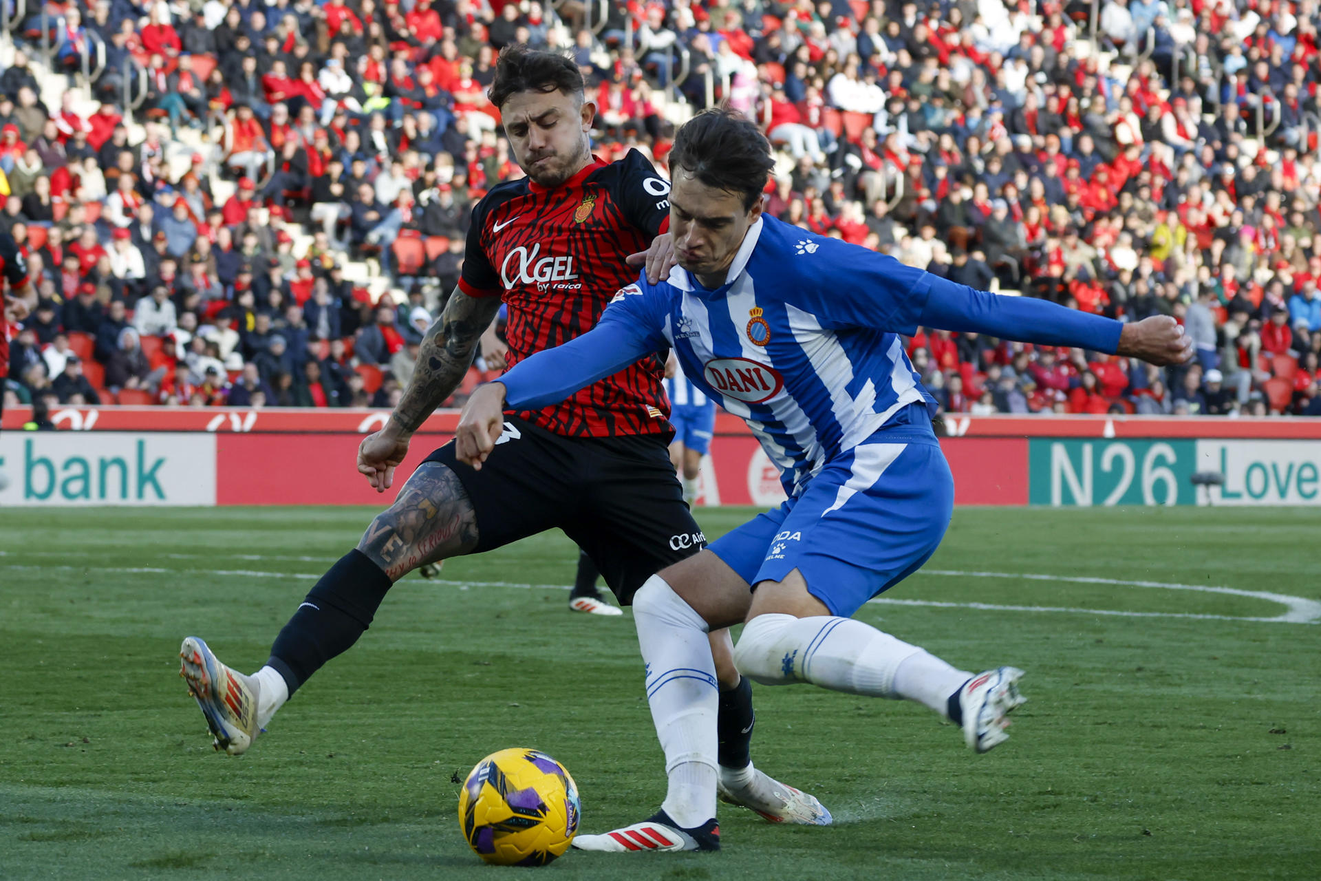 El defensa del Mallorca Pablo Maffeo (i) pelea un balón con el centrocampista del Espanyol Urko González durante el partido de LaLiga entre el Mallorca y el Espanyol, este sábado en el estadio de Son Moix. EFE/ Cati Cladera