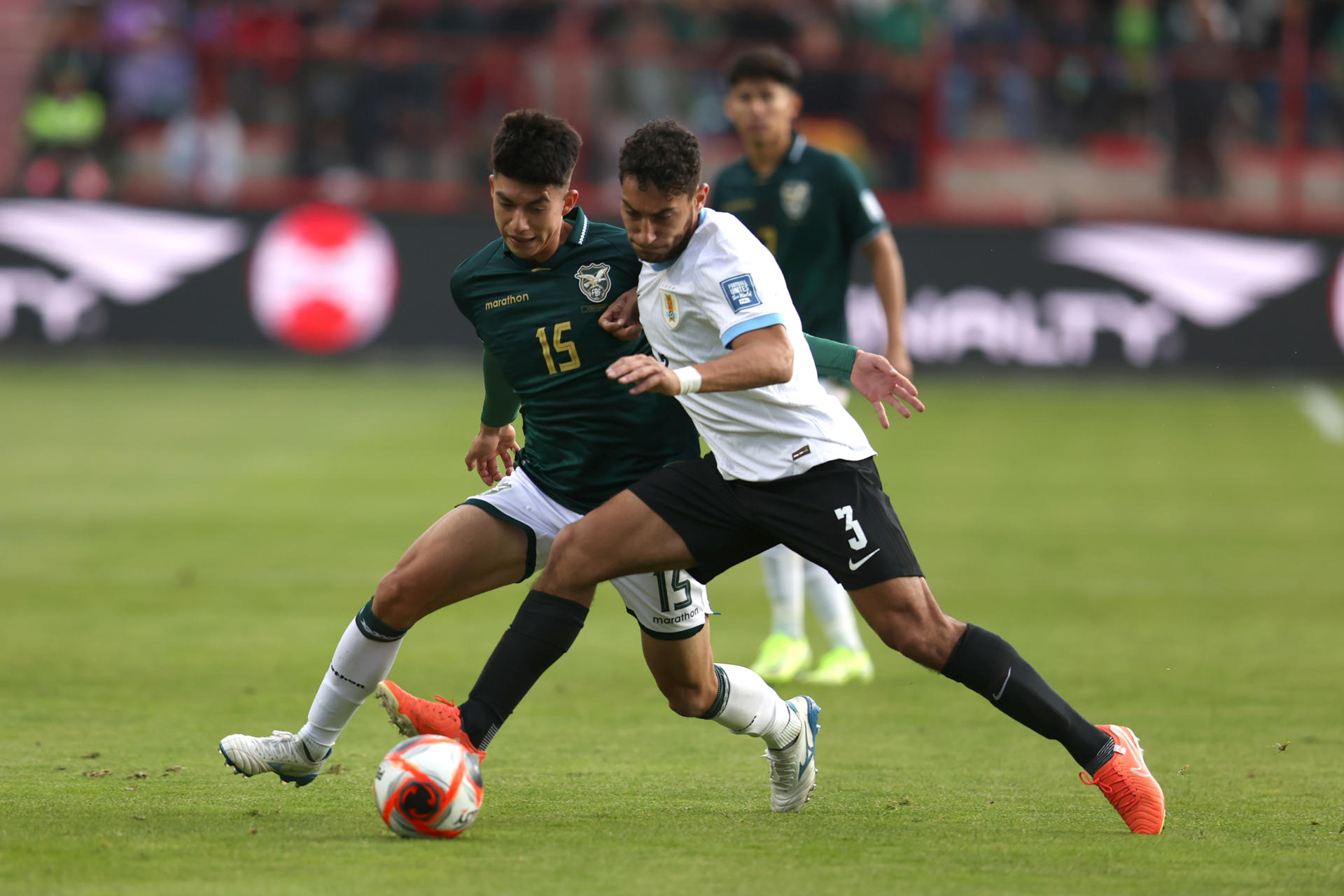 Gabriel Villamíl (i) de Bolivia disputa un balón con Sebastián Cáceres de Uruguay en un partido de las eliminatorias sudamericanas para el Mundial de 2026. EFE/ Luis Gandarillas
