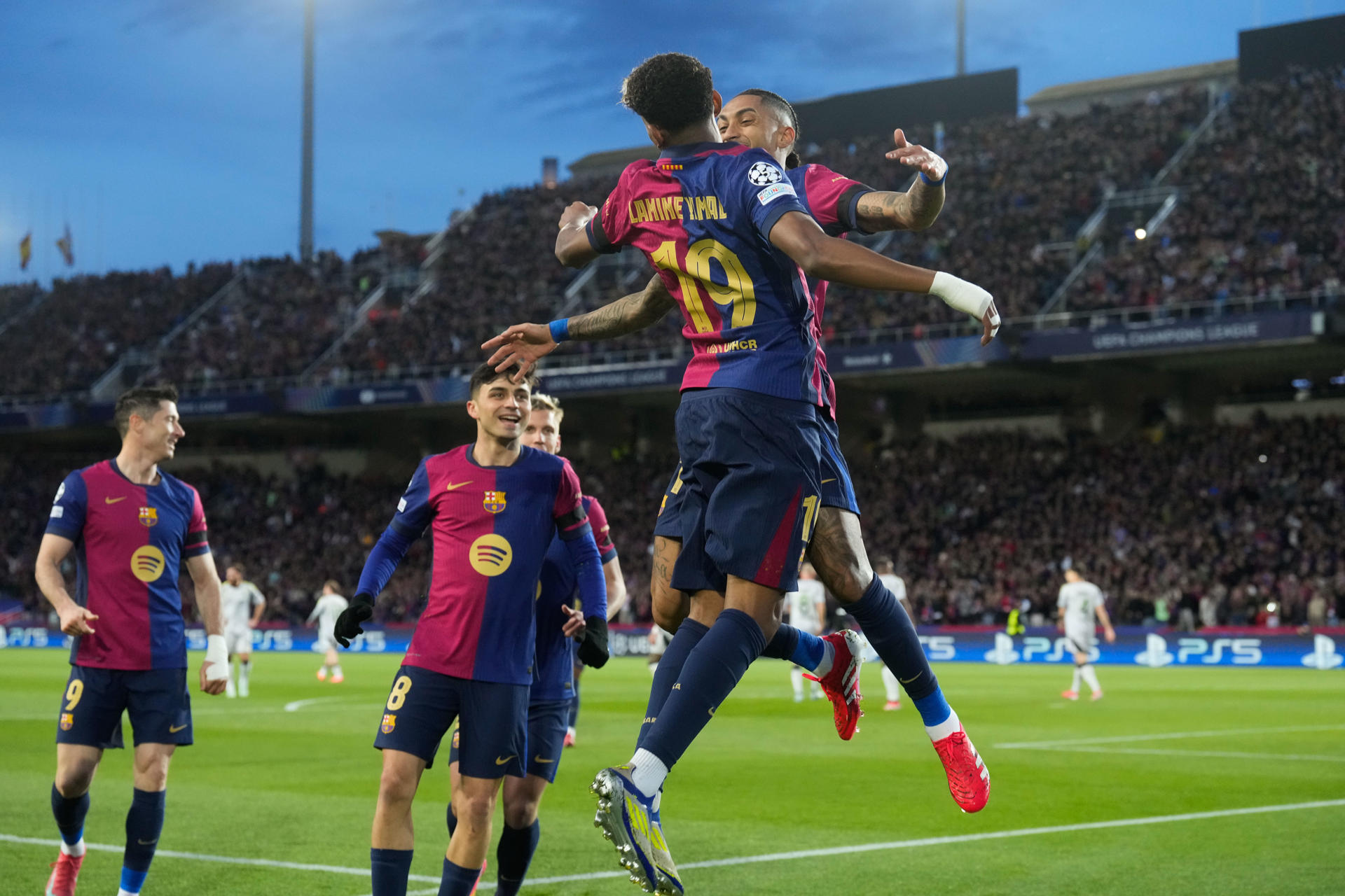 El centrocampista brasileño del Barcelona Raphinha (d), junto al delantero Lamine Yamal (2d), celebra su gol contra el Benfica, durante el partido de vuelta de octavos de final de la Liga de Campeones entre el Barcelona y el Benfica, este martes en el Estadi Olímpic Lluís Companys en Barcelona. EFE/ Enric Fontcuberta