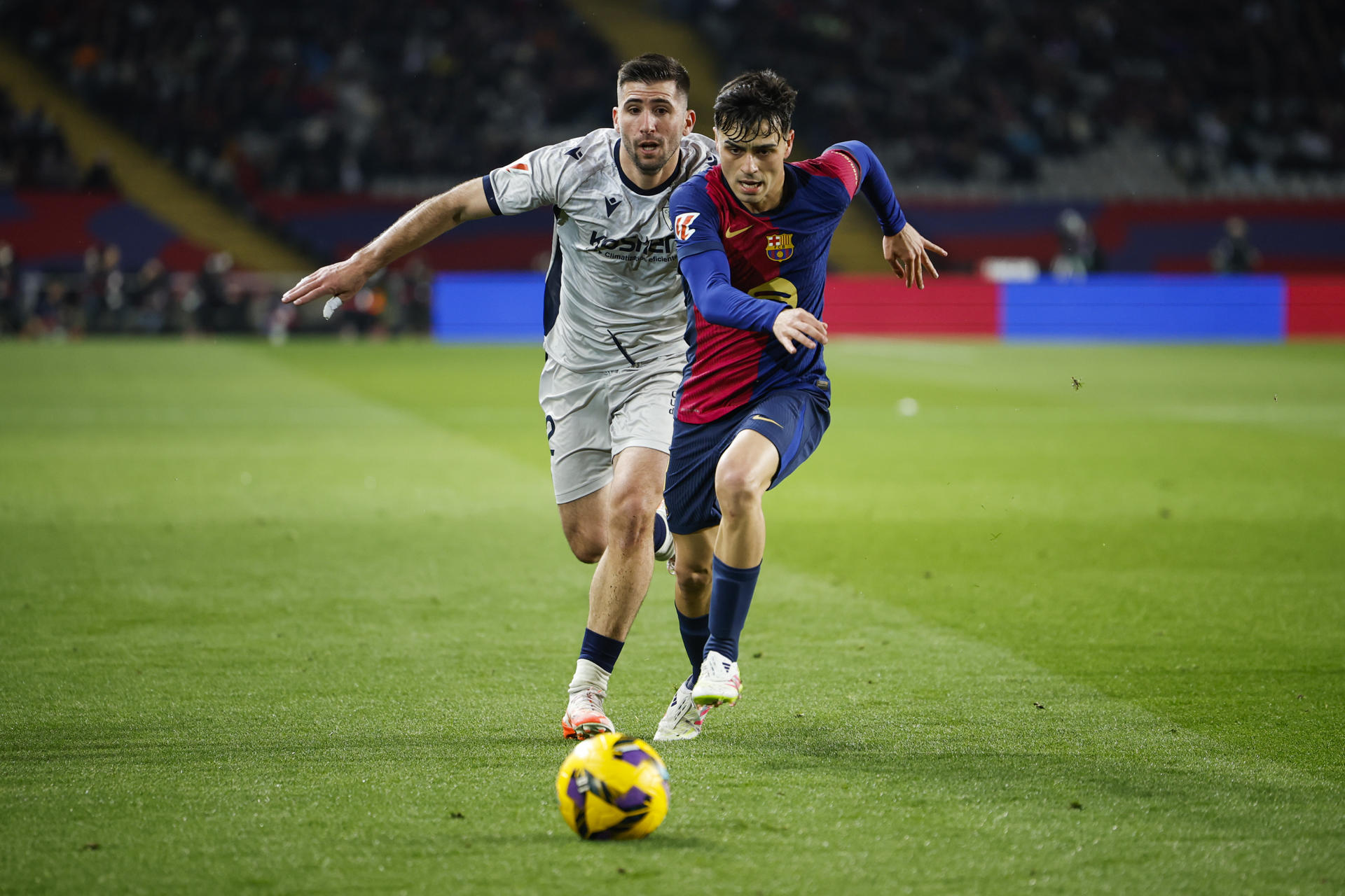 El centrocampista del Barcelona Pedri se escapa del jugador del Osasuna Jesus Areso, durante el partido entre ambos equipos en el Estadio Olímpico de Montjuic. EFE/Alberto Estevez