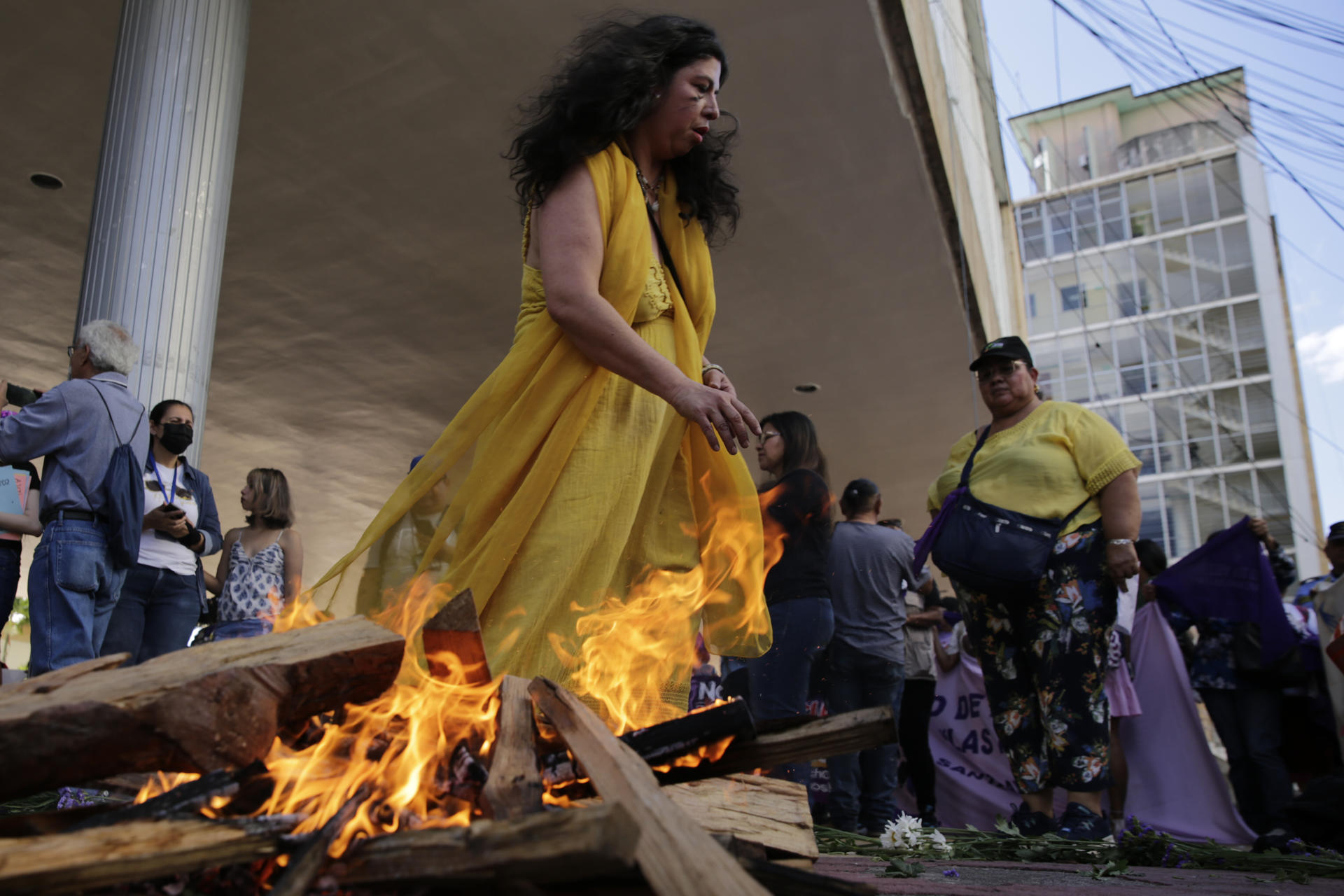 Una mujer camina frente a una fogata durante una manifestación en el marco del Día Internacional de la Mujer este viernes, frente al Parlamento en Tegucigalpa (Honduras). EFE/ Gustavo Amador
