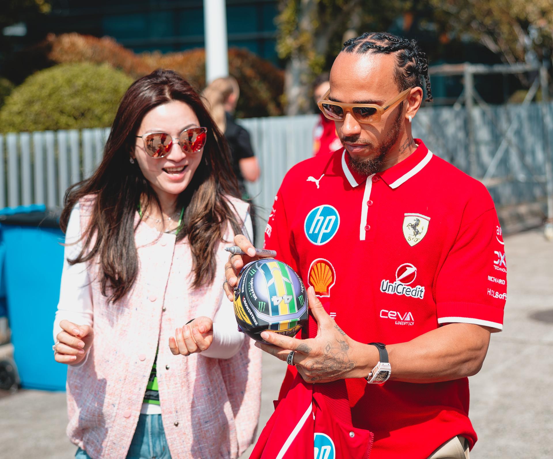 SHANGHAI (China), 20/03/2025.- El séptuple campeón mundial inglés Lewis Hamilton (Ferrari) firma un autógrafo a una aficionada a su llegada al circuito de Shanghái, sede del Gran Premio de China de Fórmula Uno, el segundo del Mundial. EFE/EPA/ALEX PLAVEVSKI