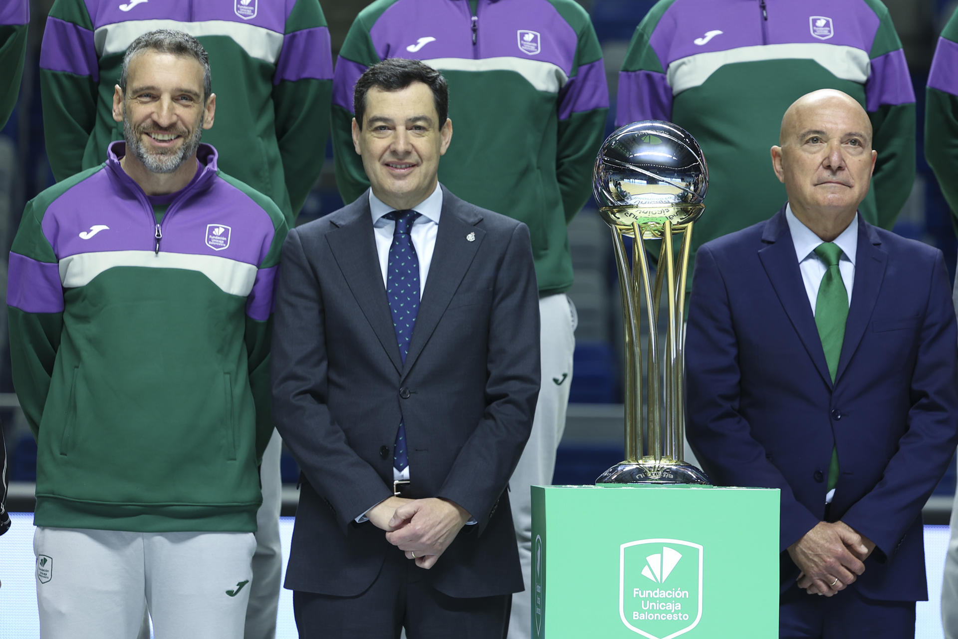 El presidente de la Junta de Andalucía, Juanma Moreno (c), posa junto al entrenador del Unicaja Baloncesto de Málaga, Ibon Navarro (i), y el presidente del club (d), Antonio Jesús López Nieto, junto al trofeo de la Copa del Rey. EFE/Daniel Pérez