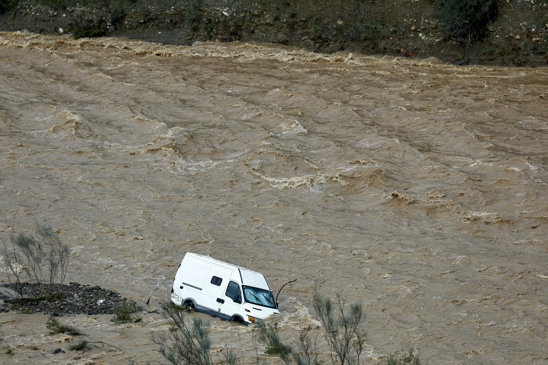 Una furgoneta es arrastrada por el río Campanillas a su paso por Almogía, en la estación de Gobernantes, este martes. EFE/Jorge Zapata